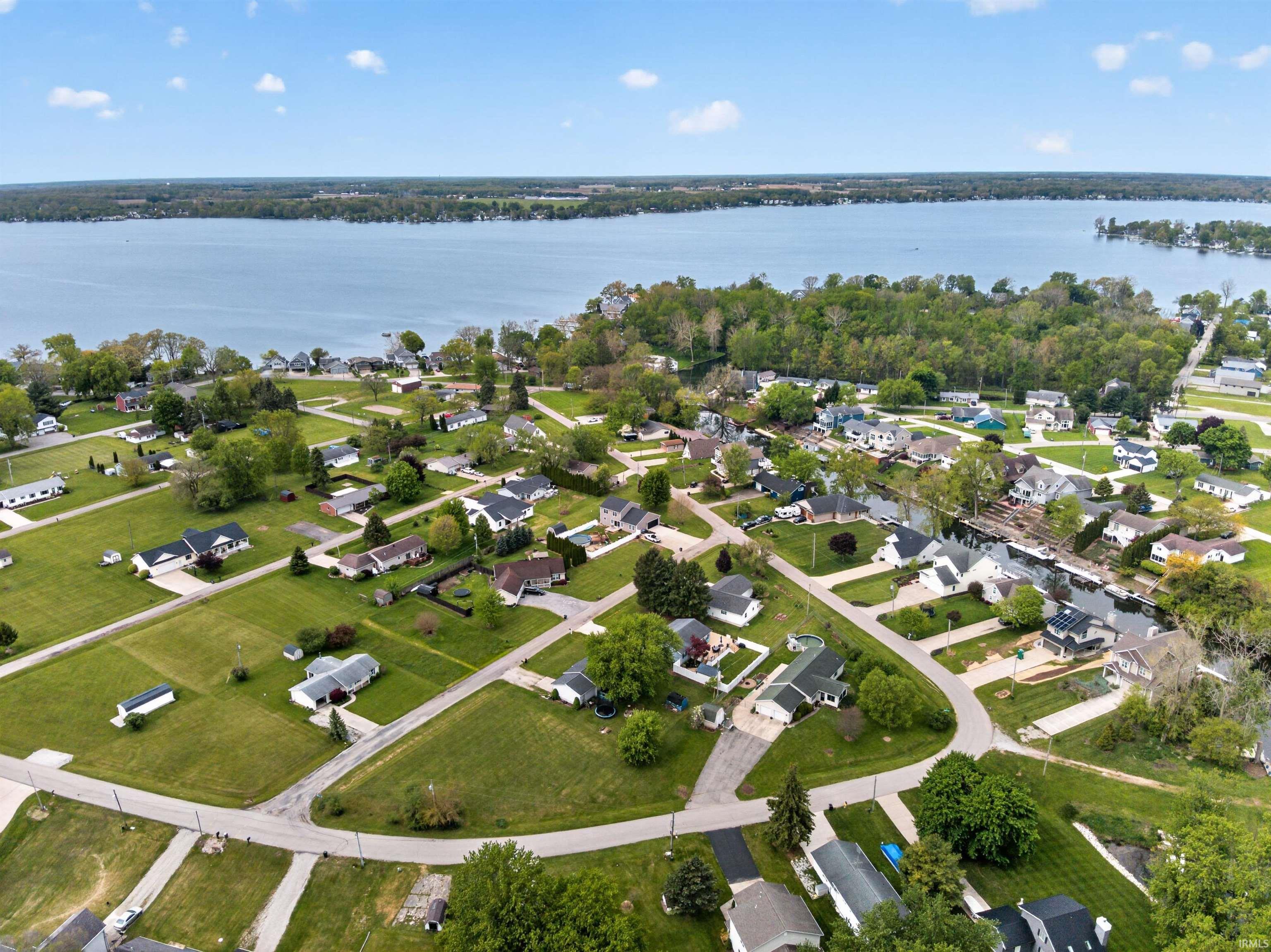 Image 2: Aerial depiction of a residential neighborhood with properties featuring green lawns and mature trees, Aerial View Image 2: Aerial depiction of a residential neighborhood with properties featuring green lawns and mature trees, Aerial View