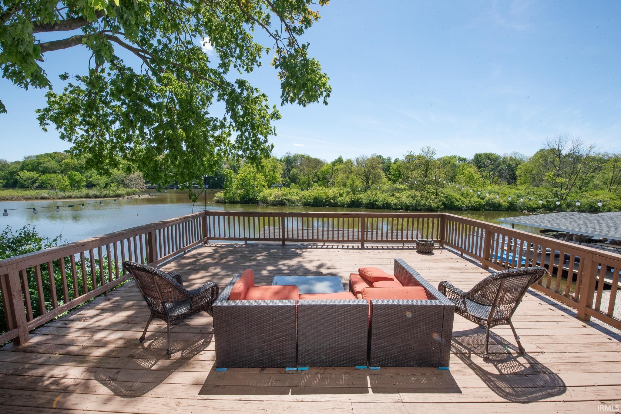 Image 2: Expansive wood-finish deck with a robust railing system overlooking a body of water, Deck Image 2: Expansive wood-finish deck with a robust railing system overlooking a body of water, Deck