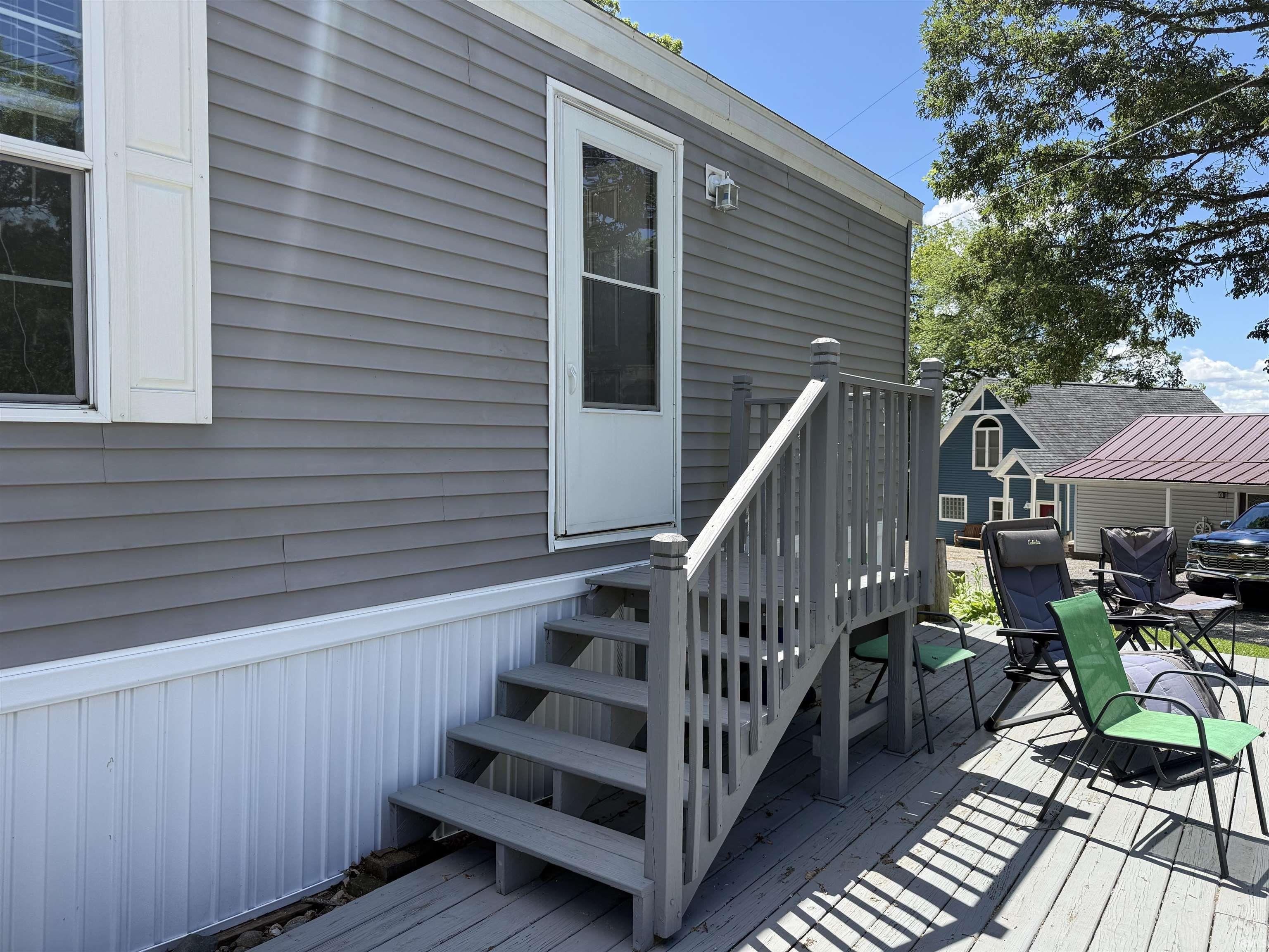 Image 2: Side entrance featuring grey horizontal siding and white trim, Deck