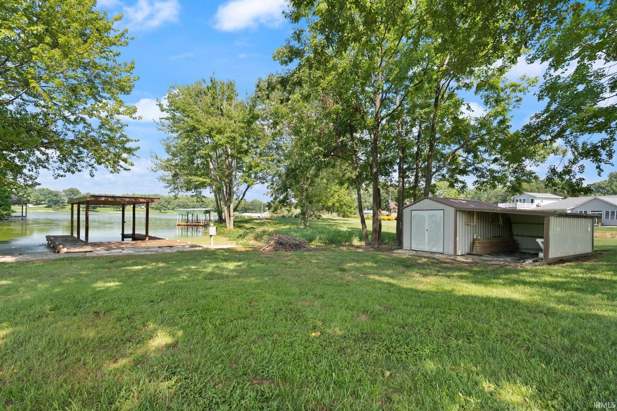 Image 2: View of grassy yard featuring a shed and a water view, Yard