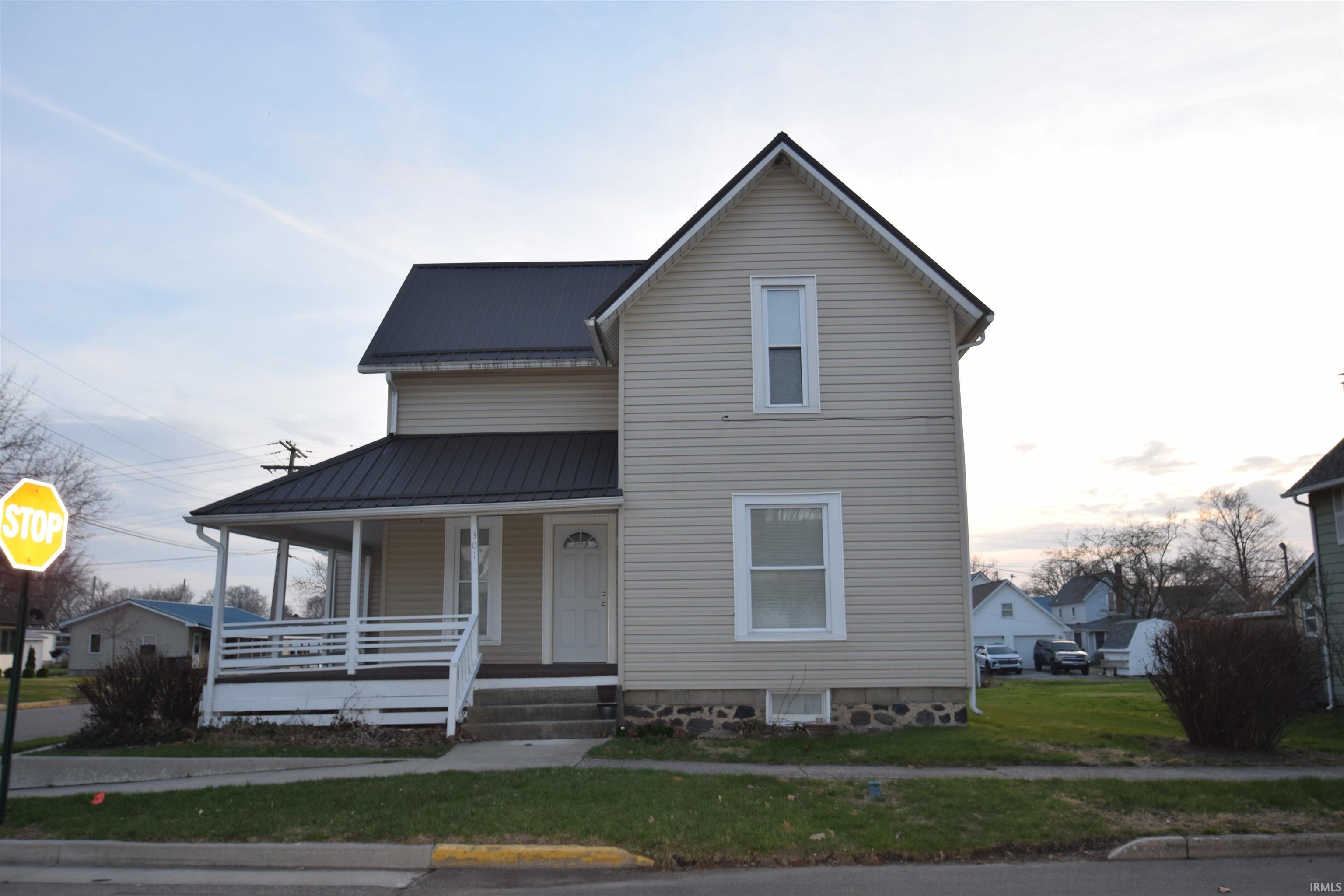 Image 1: View of front of house featuring a metal roof, a porch, and a front lawn, Front Of Structure
