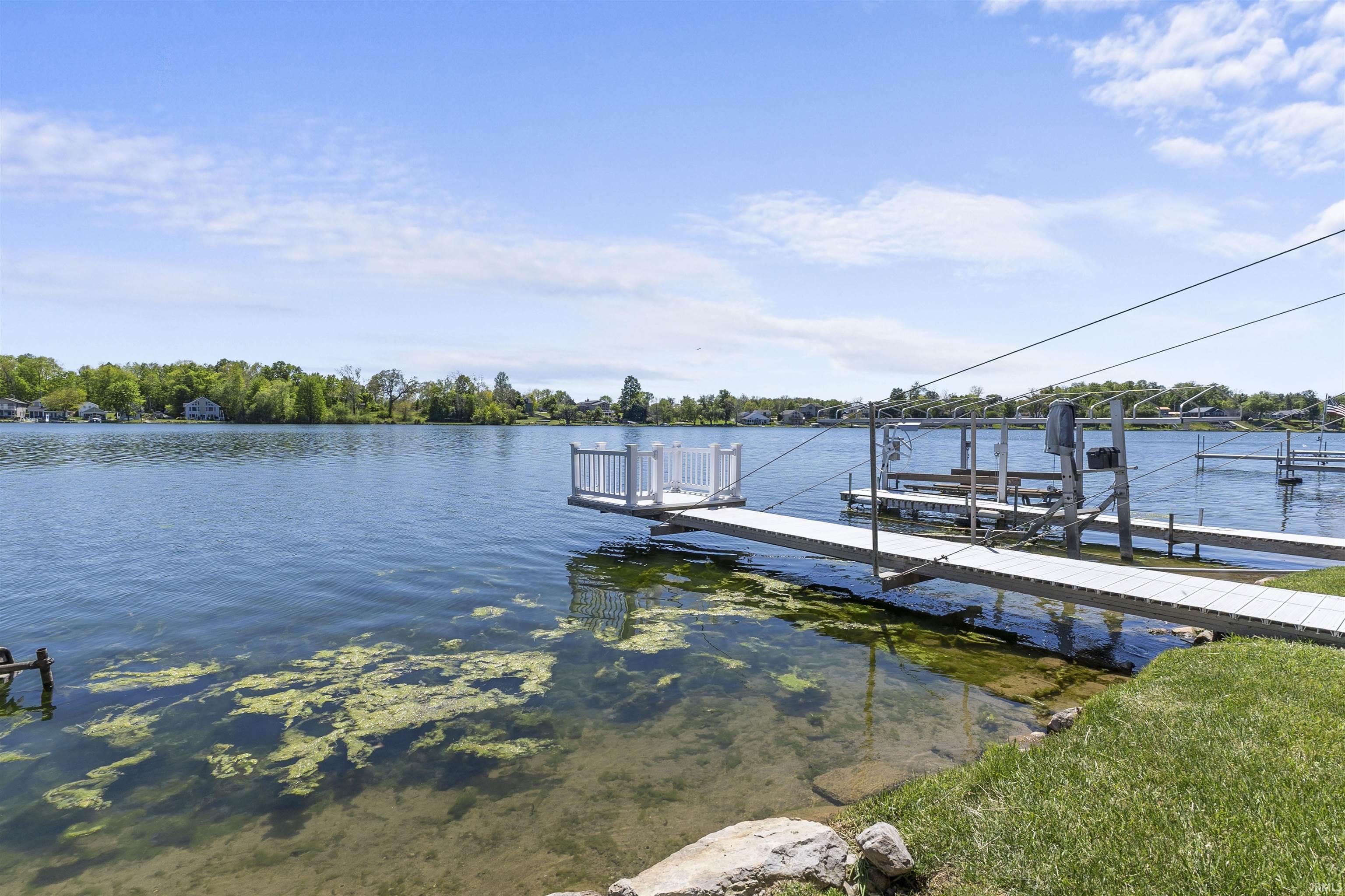 Image 2: Waterfront property featuring a private boat dock, boat lift, and clear water access, Dock Image 2: Waterfront property featuring a private boat dock, boat lift, and clear water access, Dock