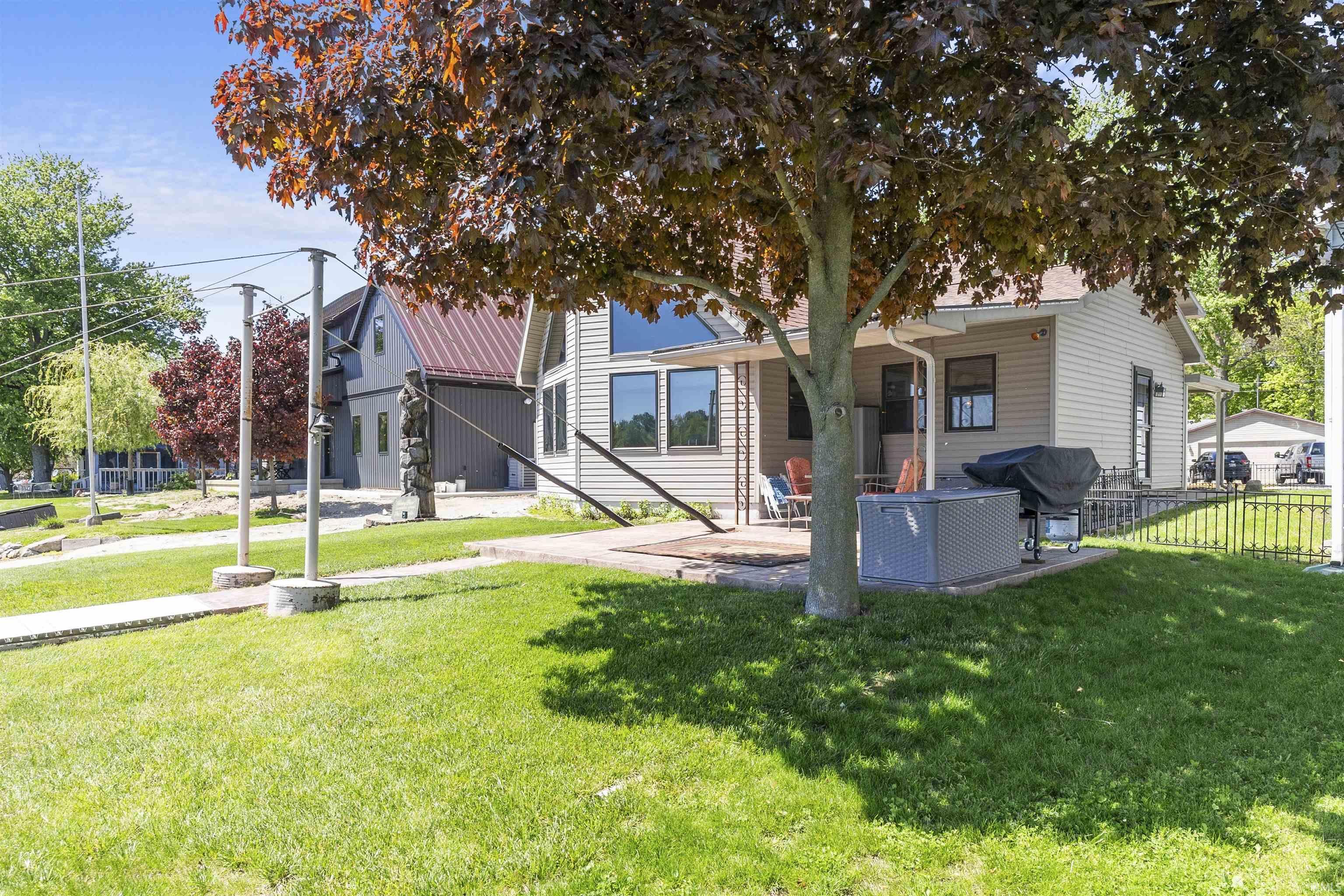 Image 3: Well-maintained lawn with established trees, a concrete patio, and a side porch, Back Of Structure Image 3: Well-maintained lawn with established trees, a concrete patio, and a side porch, Back Of Structure