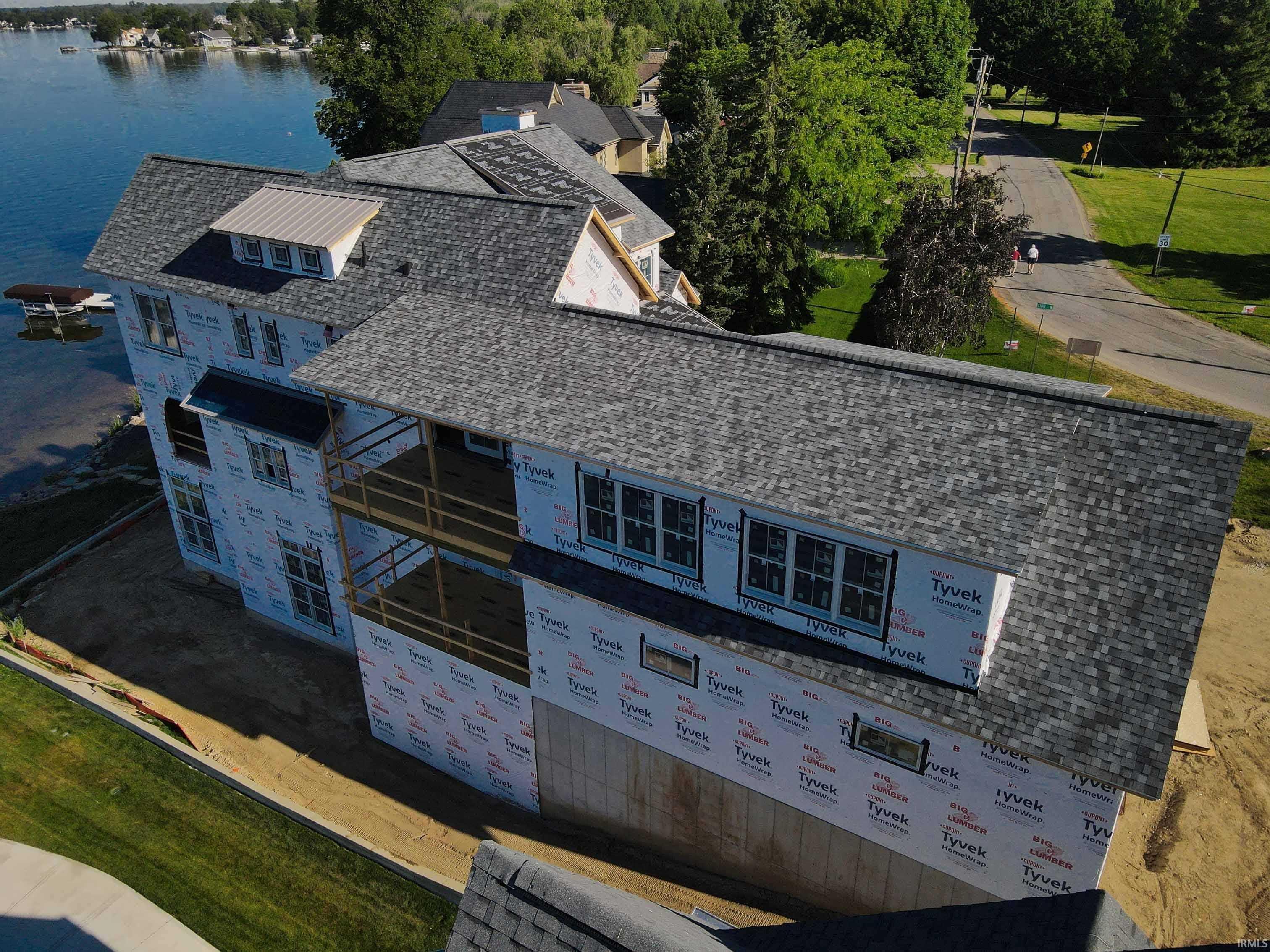 Image 2: Waterfront property under construction featuring a multi-level design, asphalt shingle roofing, and multiple balconies, Aerial View