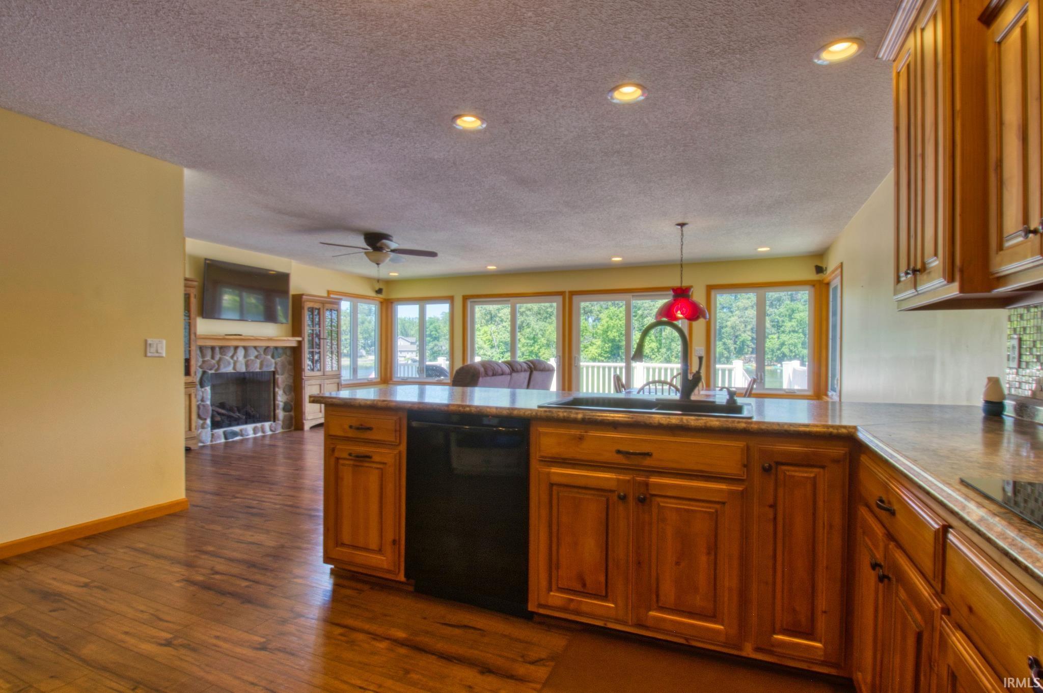 Image 3: Kitchen island with integrated sink and dishwasher, featuring wood cabinetry and a stone-finish countertop, Kitchen Image 3: Kitchen island with integrated sink and dishwasher, featuring wood cabinetry and a stone-finish countertop, Kitchen