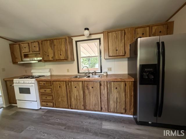 Image 1: Kitchen featuring wood-finish cabinetry, a stainless steel side-by-side refrigerator, white range with overhead exhaust, wood-finish countertops, and gray wood-finish flooring, Kitchen Image 1: Kitchen featuring wood-finish cabinetry, a stainless steel side-by-side refrigerator, white range with overhead exhaust, wood-finish countertops, and gray wood-finish flooring, Kitchen