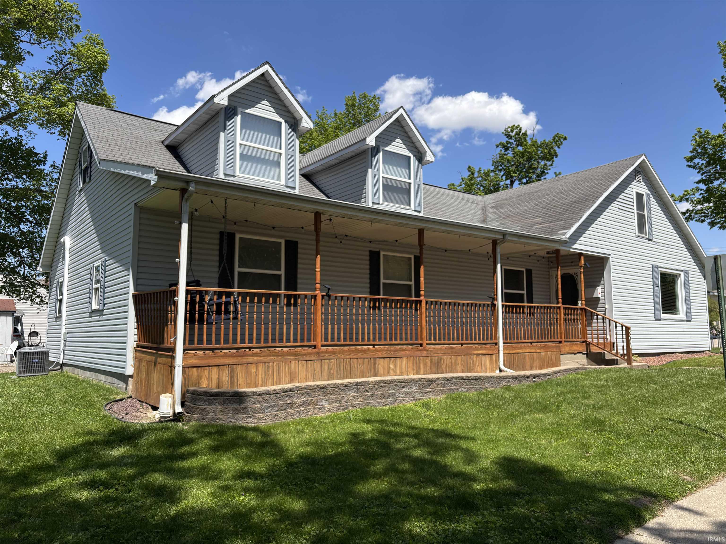 Image 0: Expansive covered front porch with a wood-finish deck and spindle railings, Front Of Structure Image 0: Expansive covered front porch with a wood-finish deck and spindle railings, Front Of Structure