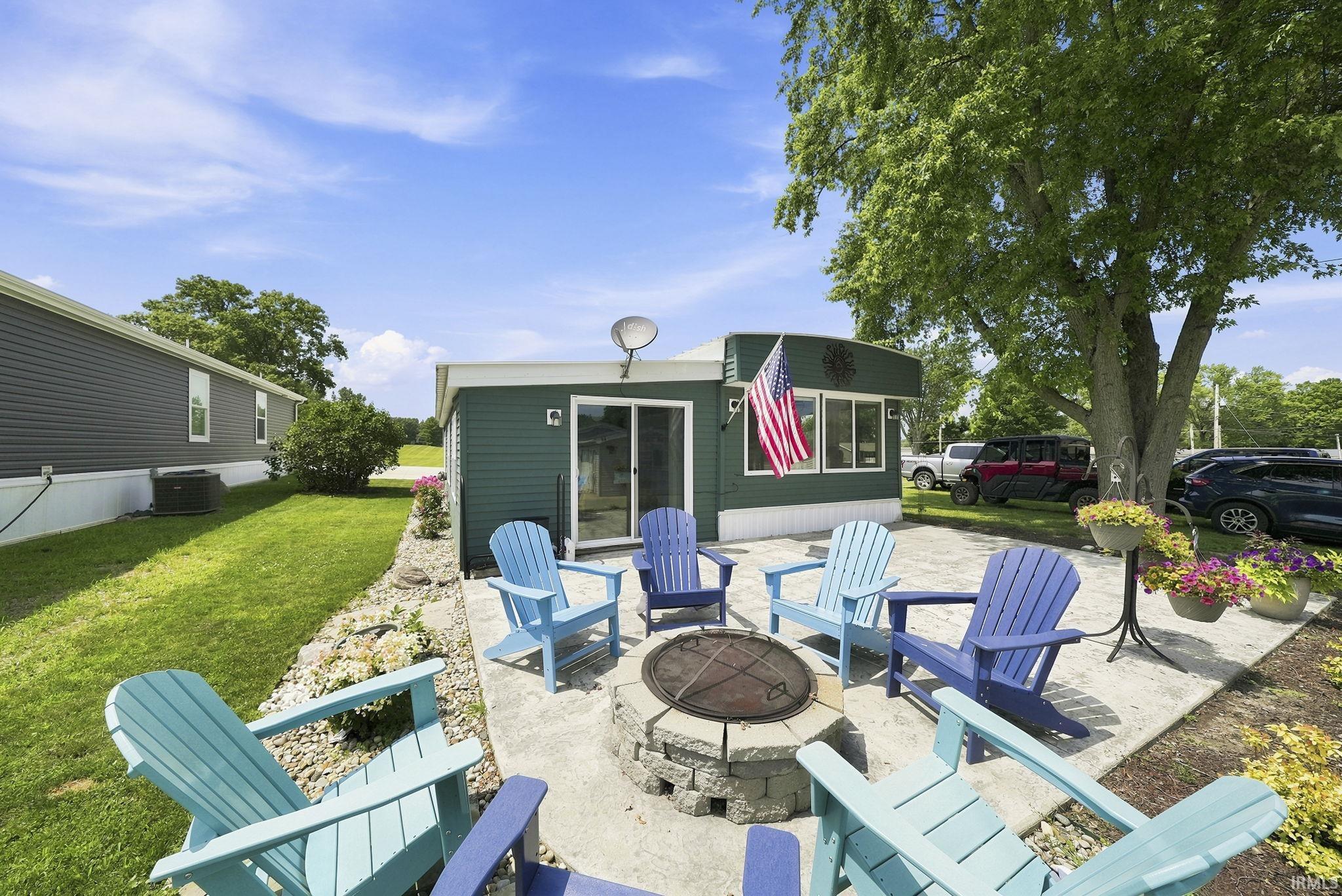 Image 0: Outdoor patio featuring a stone-clad fire pit, concrete pavers, and surrounding landscaping, Patio Image 0: Outdoor patio featuring a stone-clad fire pit, concrete pavers, and surrounding landscaping, Patio
