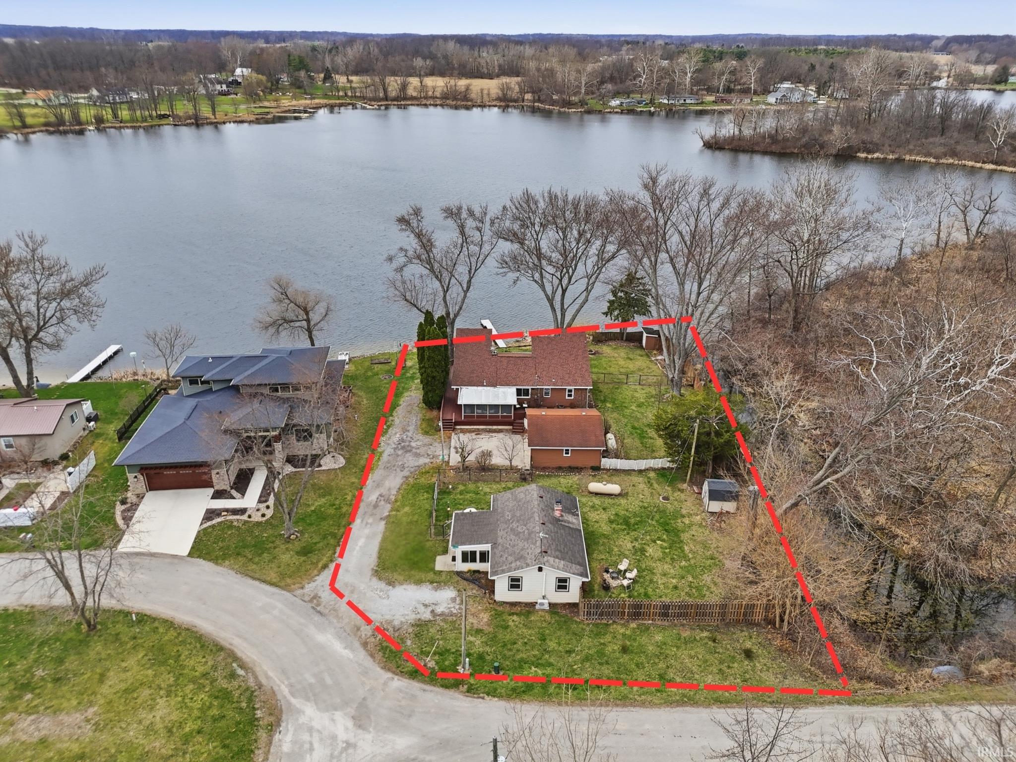 Image 1: Aerial view of residential area featuring property parcel outlined and a large body of water, Aerial View