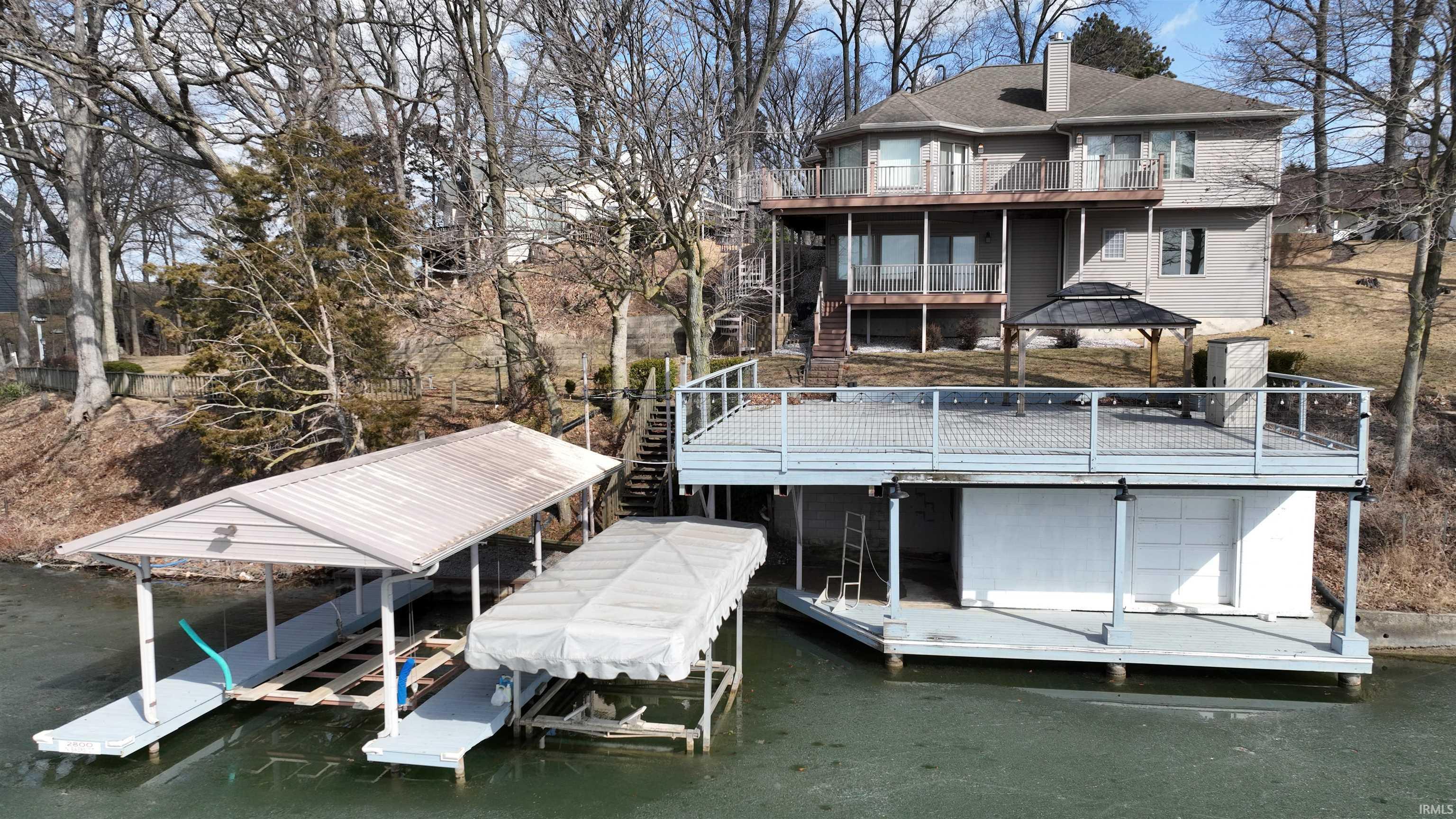 Image 2: Dock area with boat lift, a gazebo, a balcony, and a water view, Dock