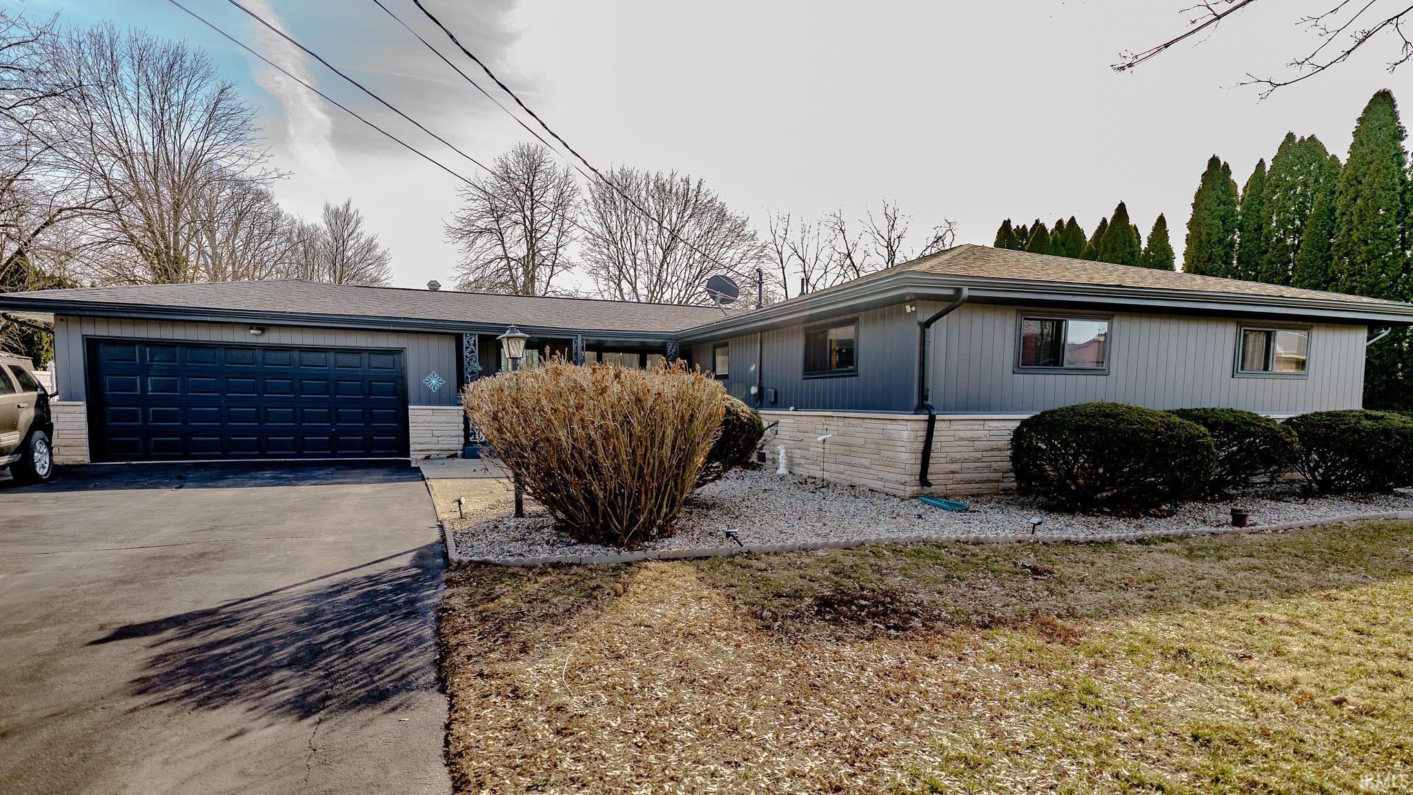 Image 0: Single story home with a garage, driveway, stone siding, and roof with shingles, Front Of Structure