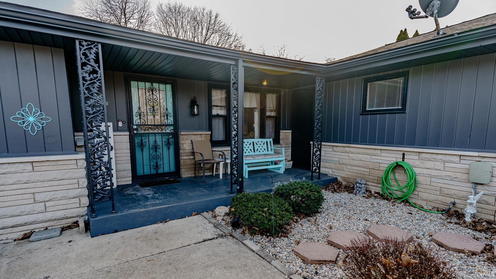 Image 1: View of exterior entry featuring a porch, board and batten siding, and stone siding, Entry