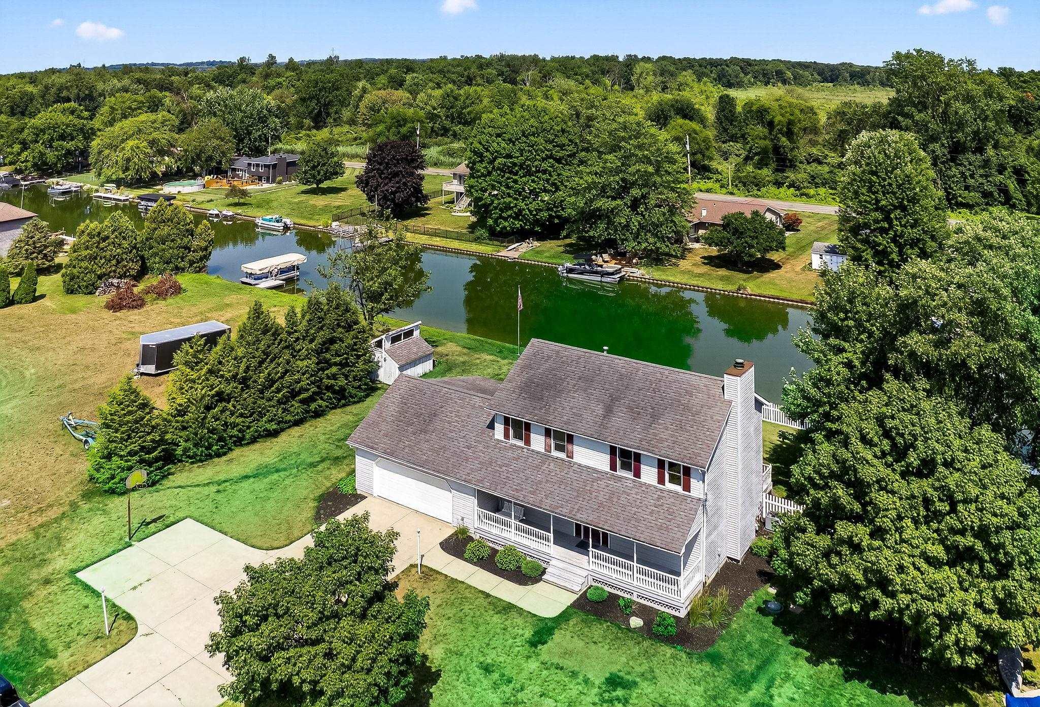 Image 0: Aerial view of property and surrounding area with a nearby body of water and a tree filled landscape, Aerial View