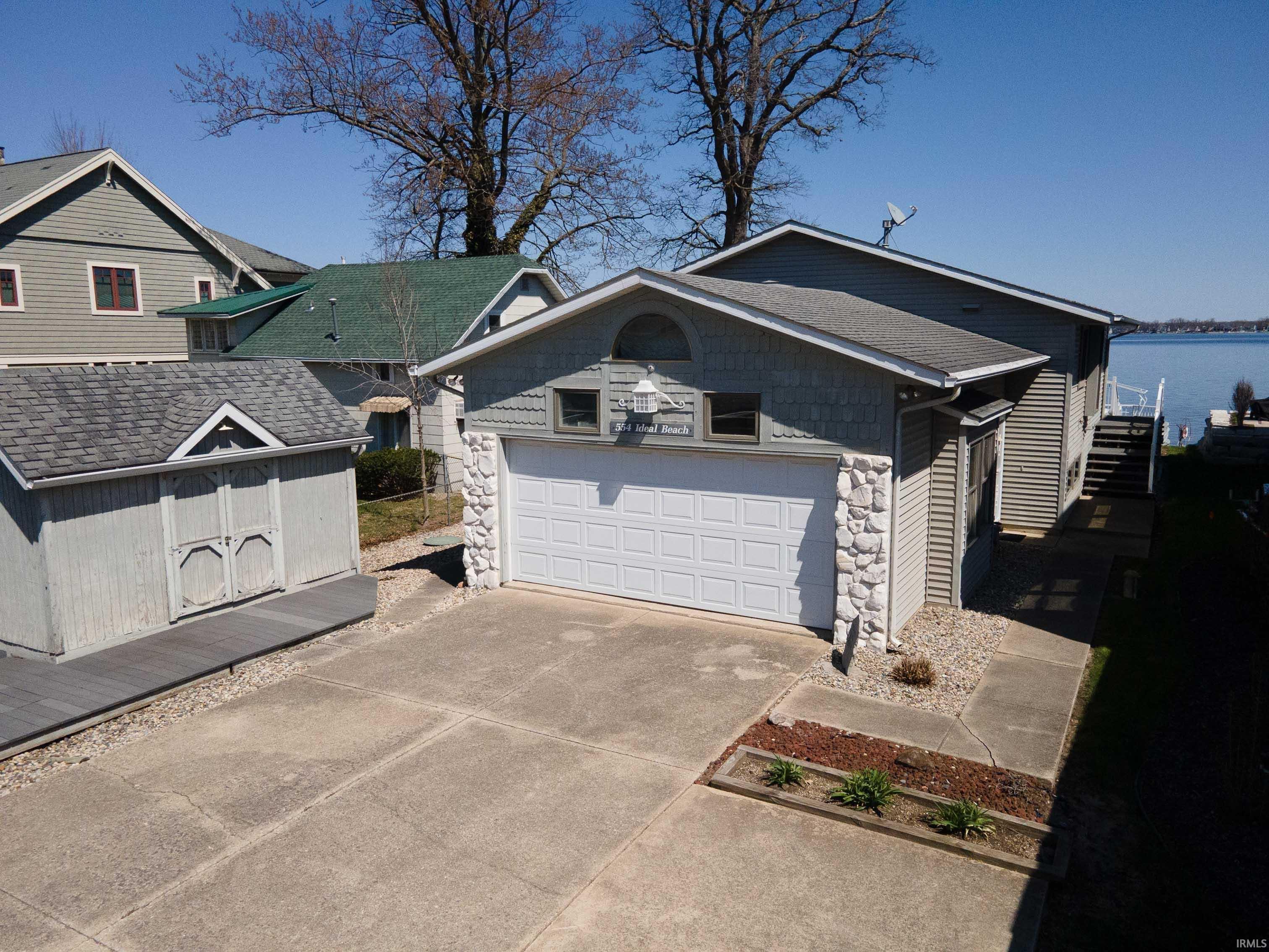 Image 0: View of front of property with driveway, stone siding, and a garage, Front Of Structure
