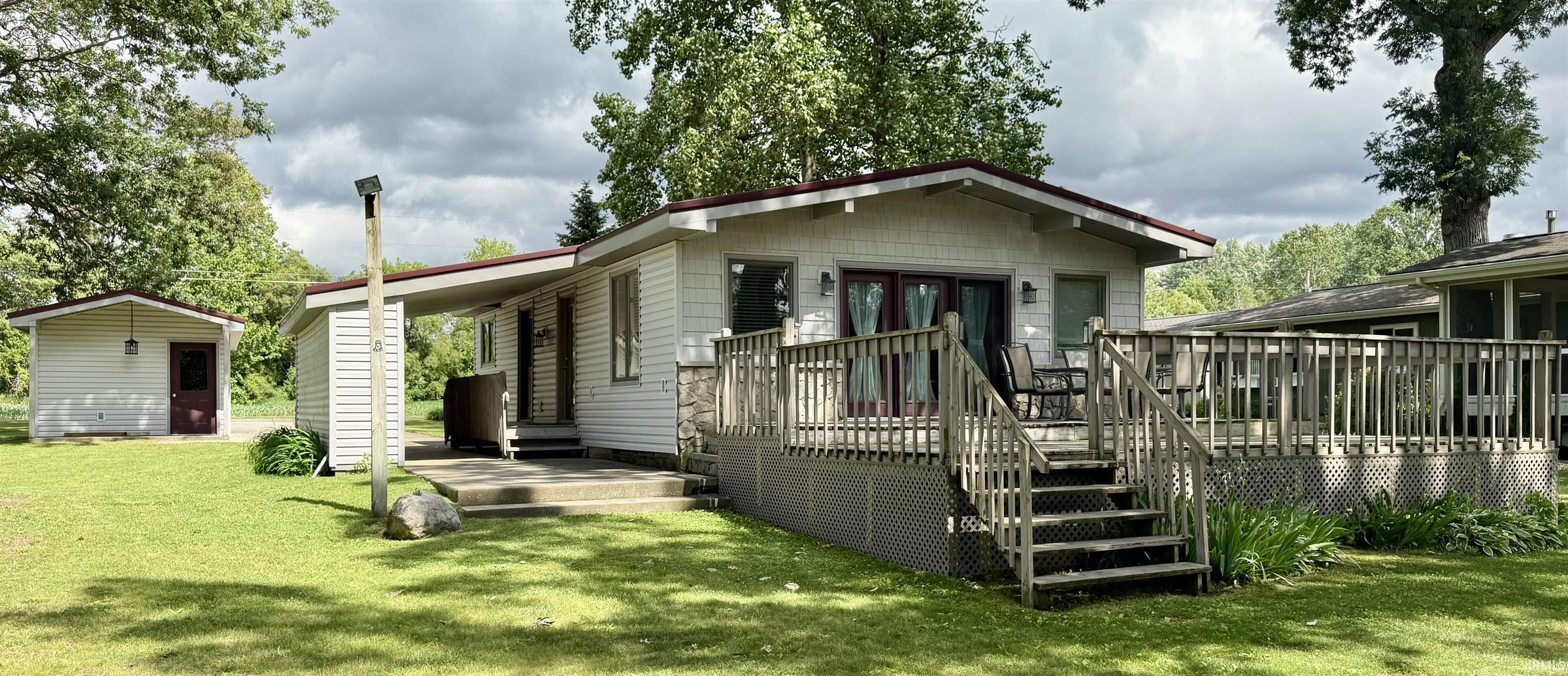 Image 0: Front of property featuring a deck and a lawn (Lakefront), Front of Structure