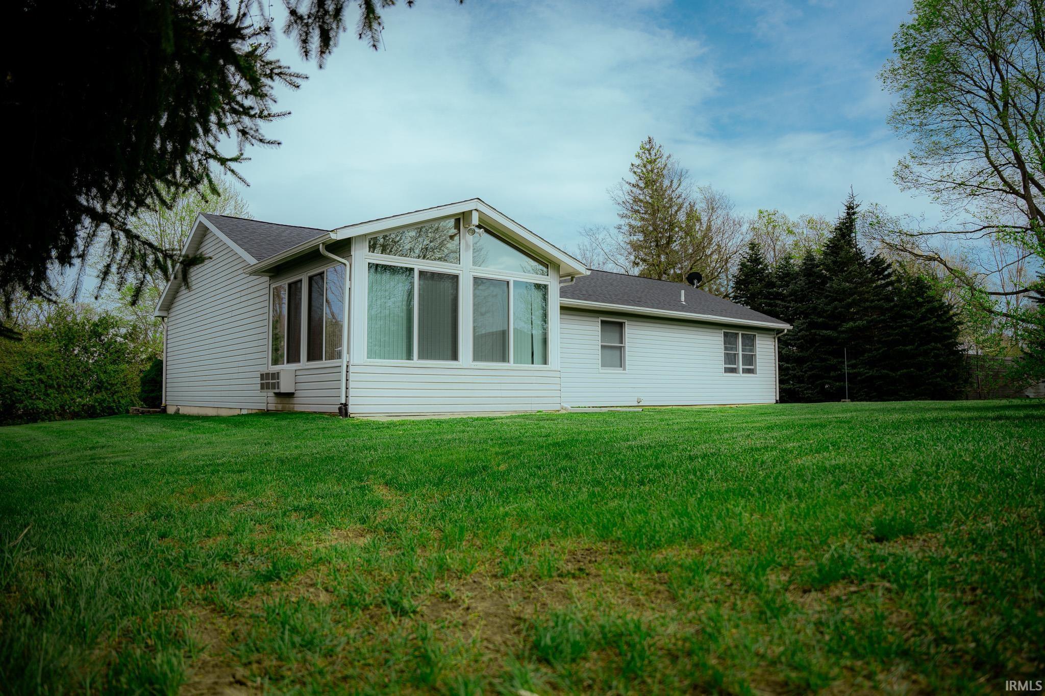 Image 1: Expansive green lawn surrounds a residence featuring light-toned siding, Back Of Structure