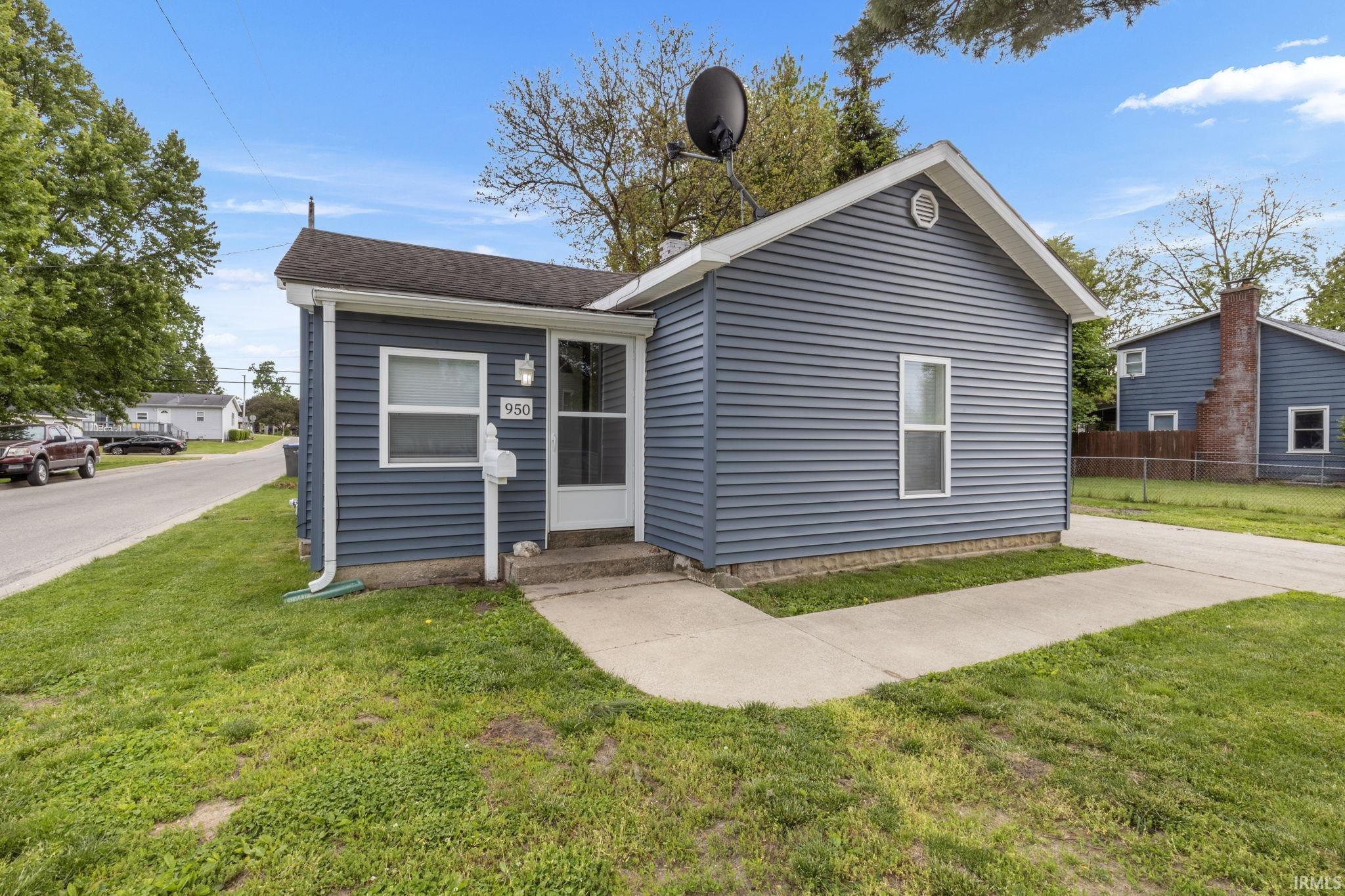 Image 1: Single-story residence featuring blue vinyl siding and a dark shingle roof, Front Of Structure