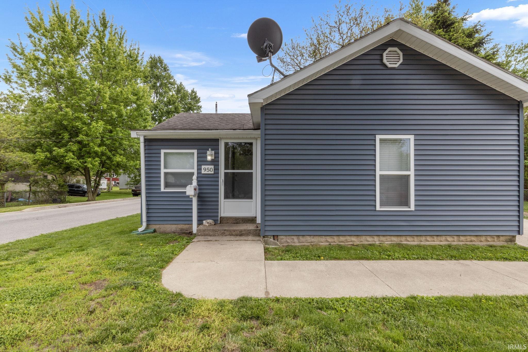 Image 2: Exterior featuring blue siding, white trim, a concrete walkway, and an arched gable vent, Front Of Structure