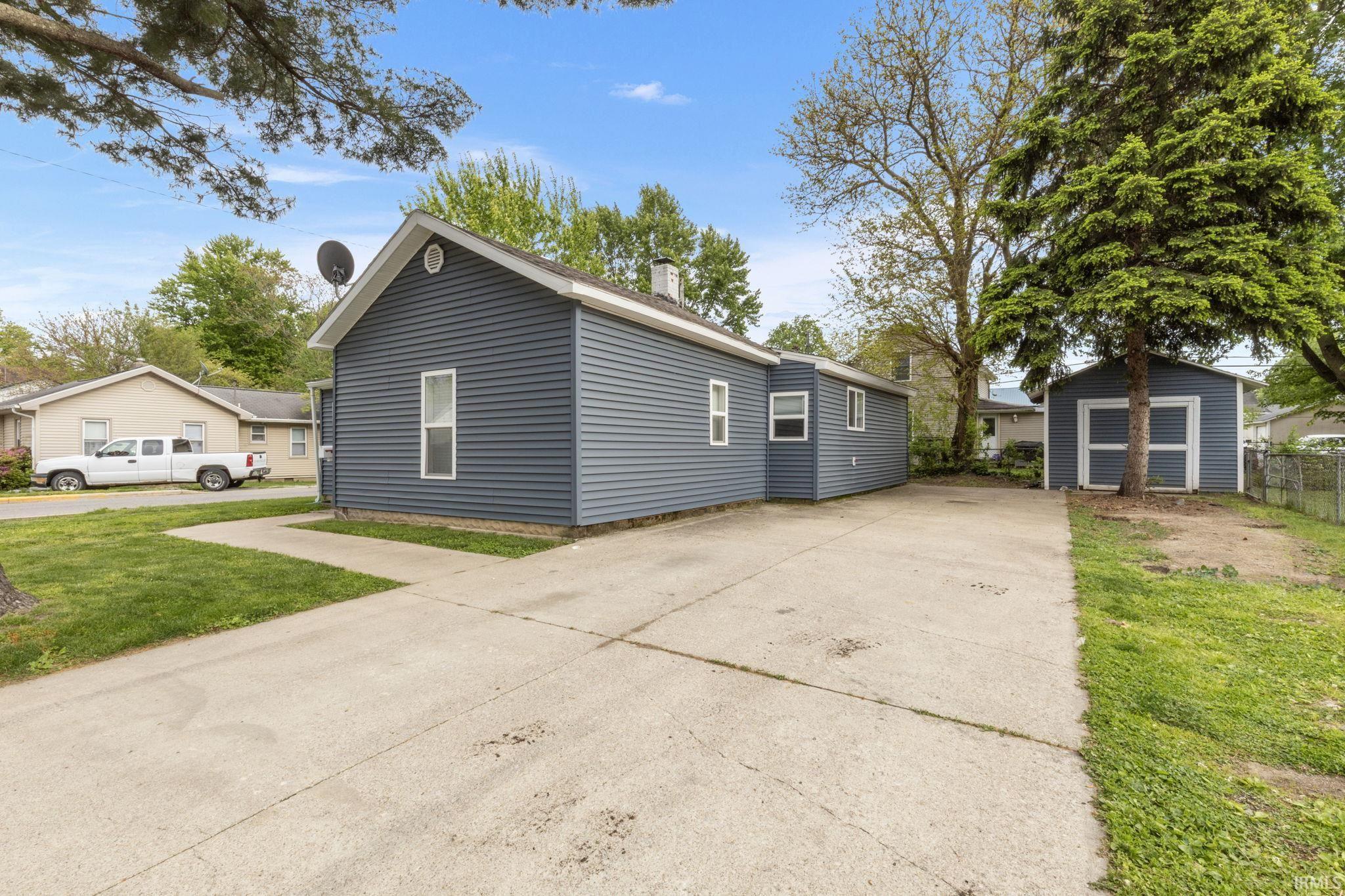 Image 3: Exterior featuring blue vinyl siding, white trim, and a gabled roofline, Side Of Structure