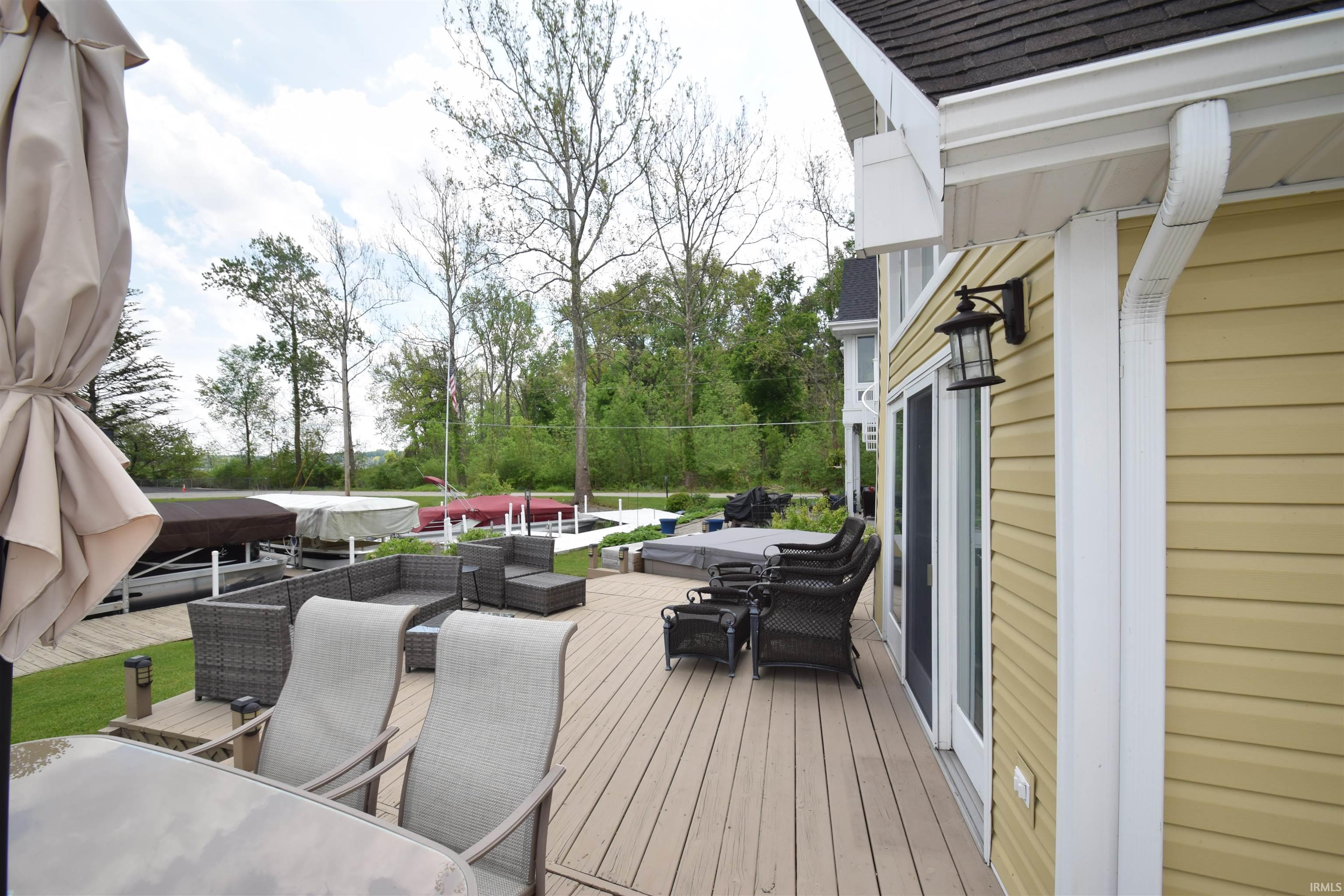 Image 1: Expansive outdoor deck featuring wood-finish flooring, direct access via sliding glass doors, and a built-in hot tub, Deck