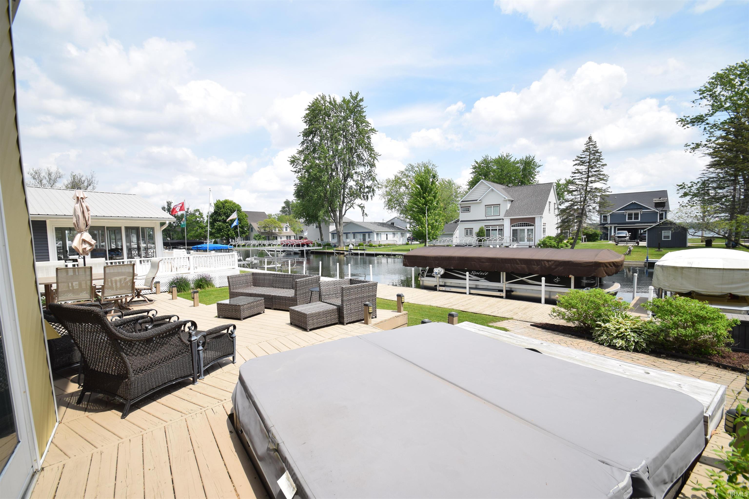 Image 2: Spacious outdoor deck with a hot tub, stone paver patio, and direct waterfront access featuring a boat lift and additional dock space, Deck