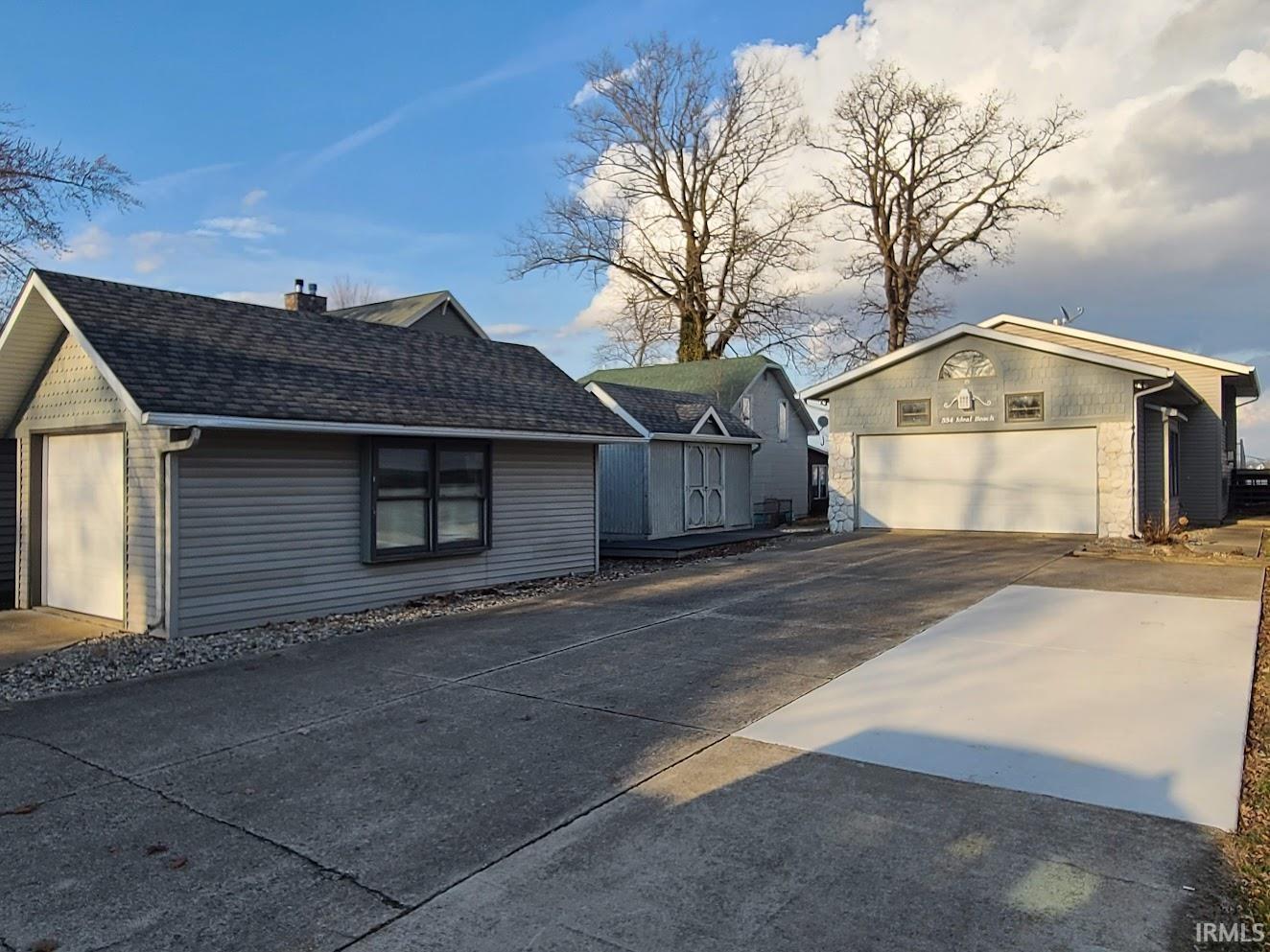 Image 2: View of home's exterior with an outbuilding, a chimney, roof with shingles, and driveway, Side Of Structure