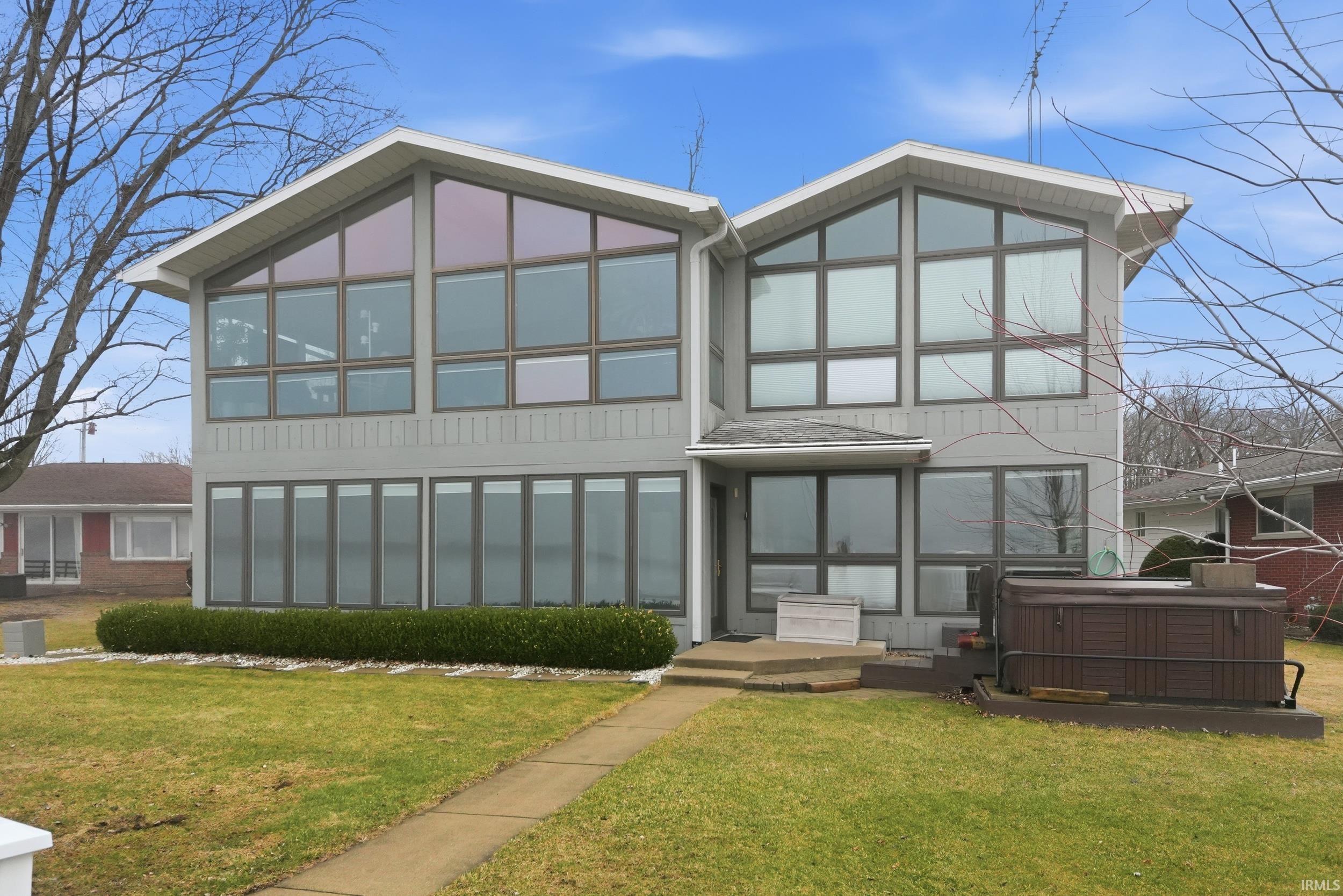 Image 3: Back of house featuring a hot tub and a lawn, Back Of Structure