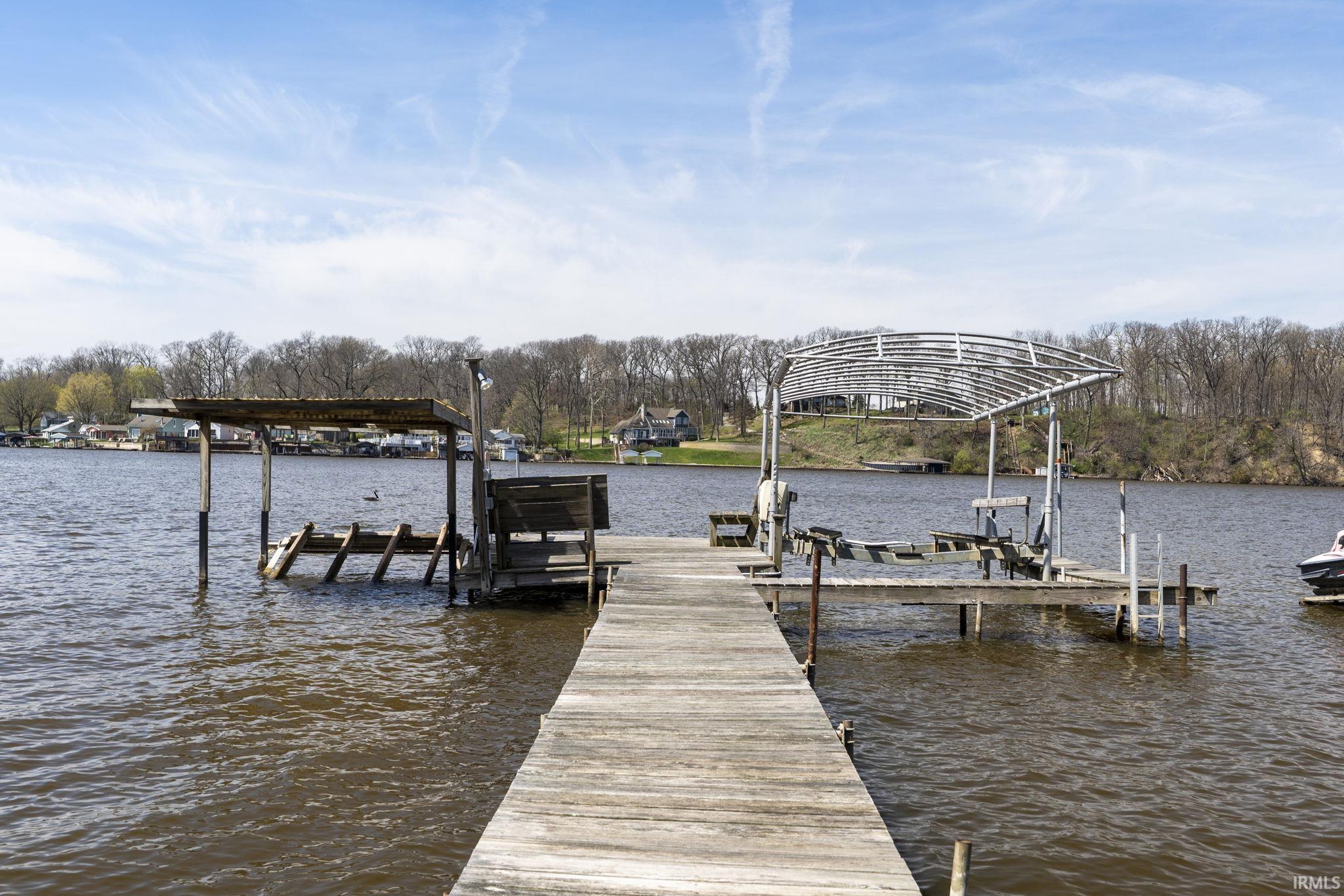 Image 2: Dock area featuring boat lift and a water view, Dock