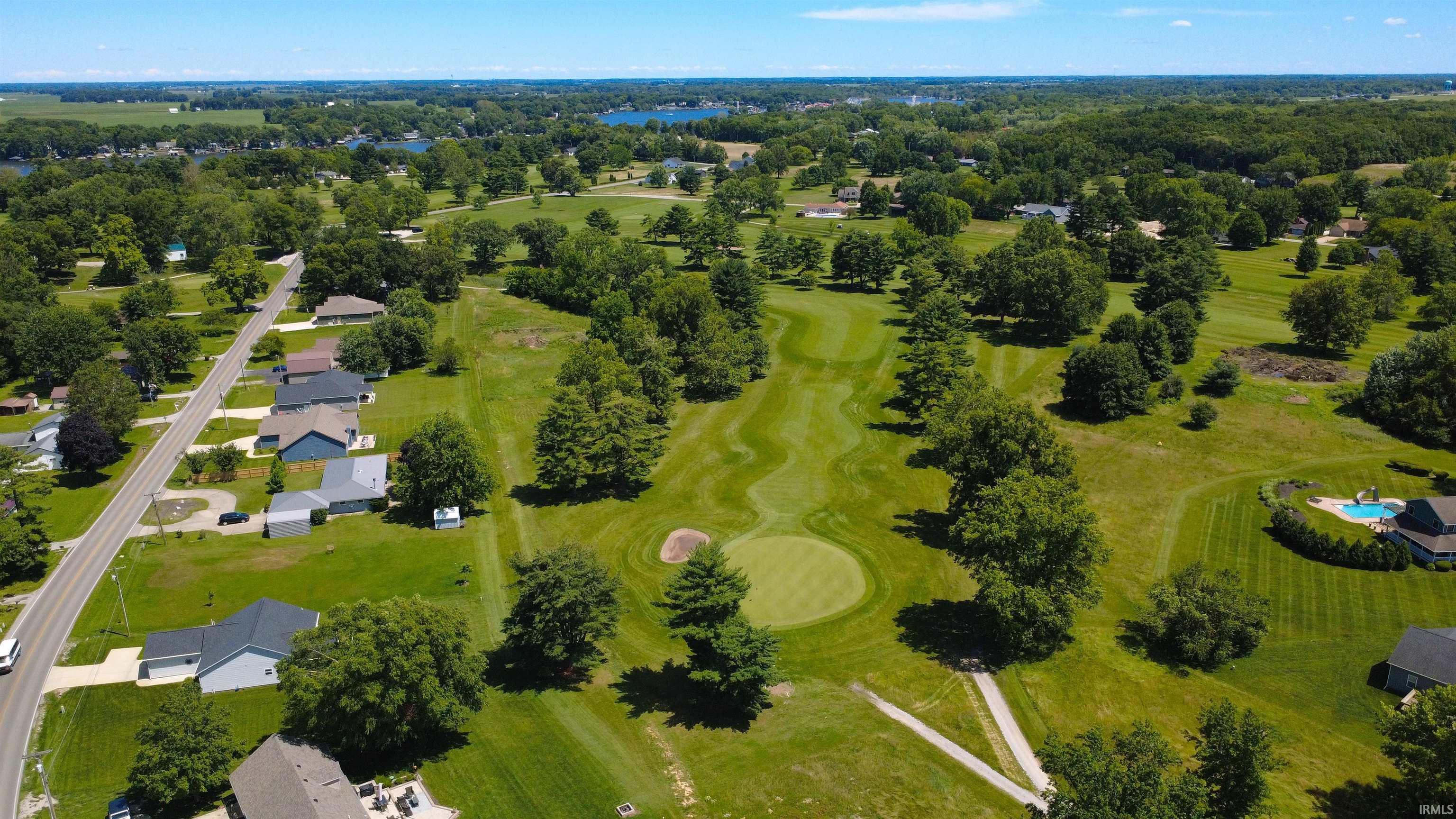 Image 1: Expansive golf course setting featuring manicured greens and mature trees, Aerial View Image 1: Expansive golf course setting featuring manicured greens and mature trees, Aerial View