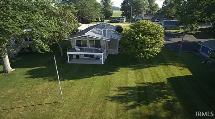 Image 0: Two-story residence featuring stone-finish siding and a metal roof, Aerial View