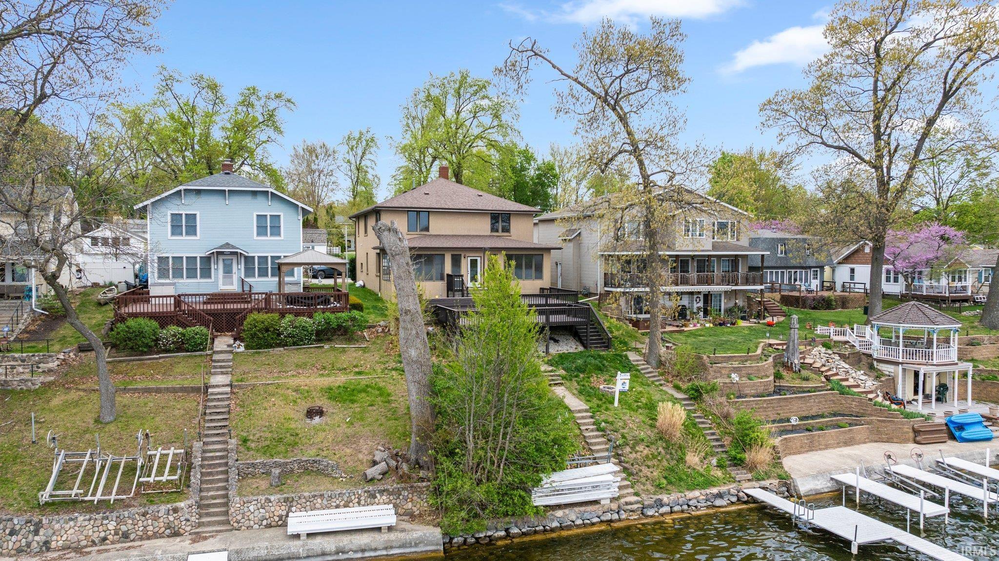 Image 1: Back of house with a water view, a residential view, and a chimney, Back Of Structure
