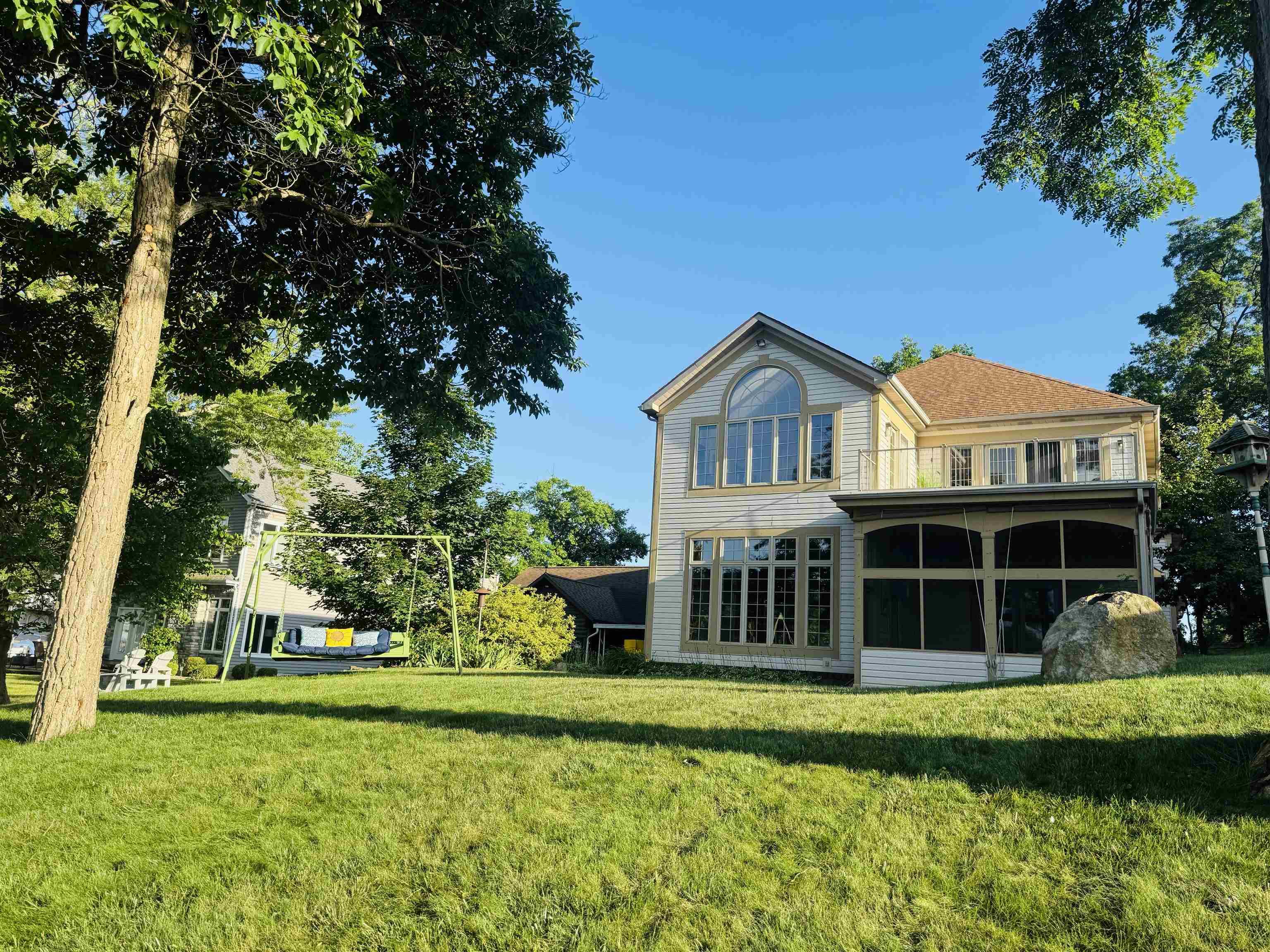 Image 3: Back of house featuring a sunroom and a yard, Lakeside View of Home facing Lake James Image 3: Back of house featuring a sunroom and a yard, Lakeside View of Home facing Lake James
