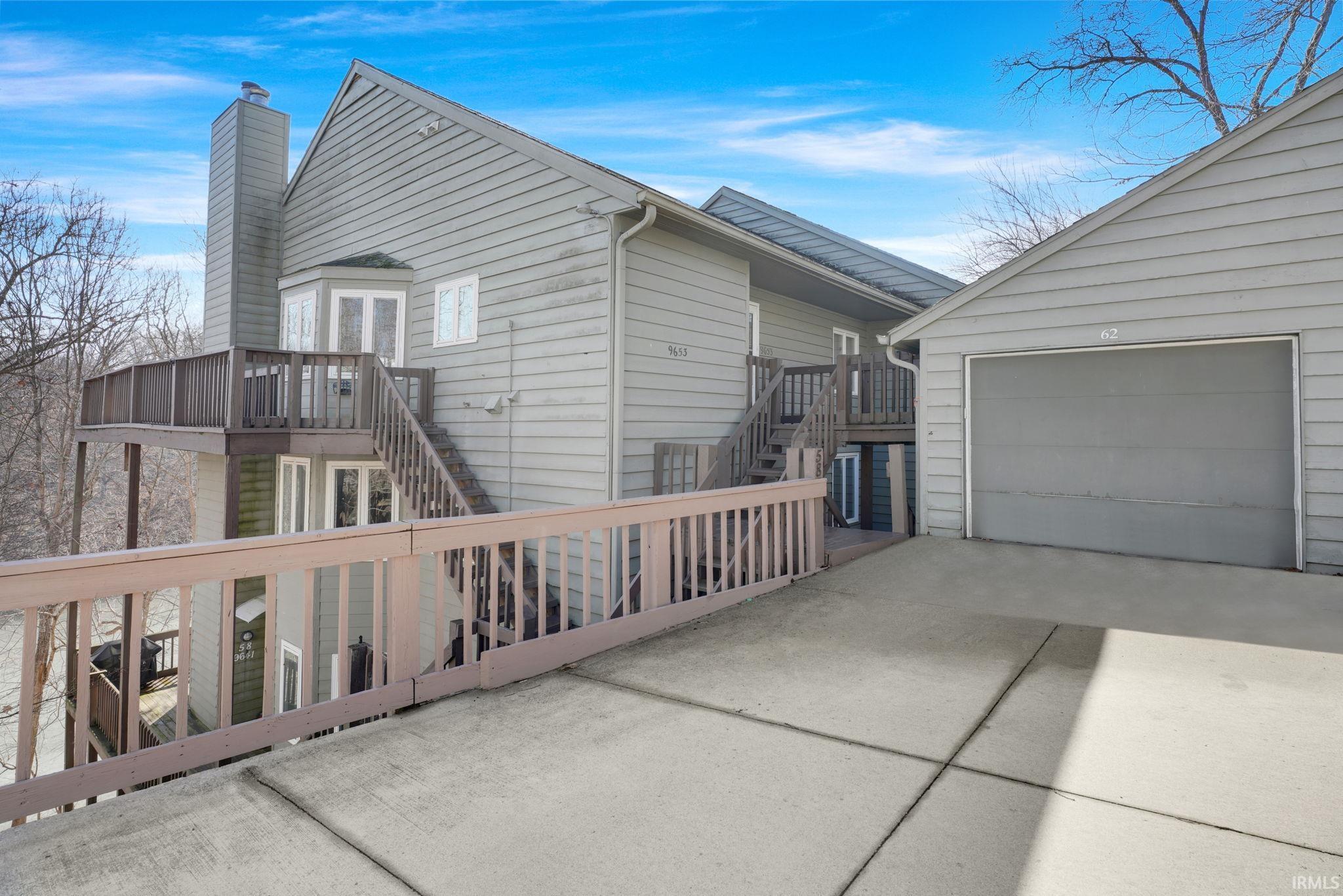 Image 1: View of side of home featuring a chimney, concrete driveway, and a garage, Side Of Structure Image 1: View of side of home featuring a chimney, concrete driveway, and a garage, Side Of Structure