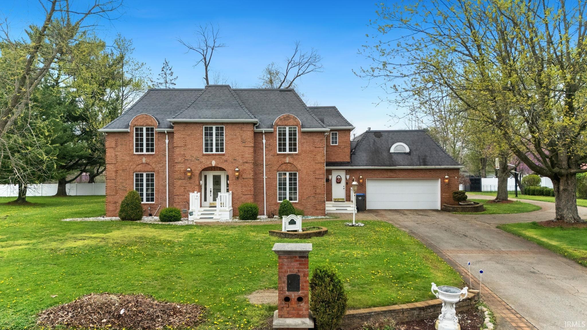 Image 1: View of front of house with a front yard, an attached garage, driveway, roof with shingles, and brick siding, Front Of Structure Image 1: View of front of house with a front yard, an attached garage, driveway, roof with shingles, and brick siding, Front Of Structure