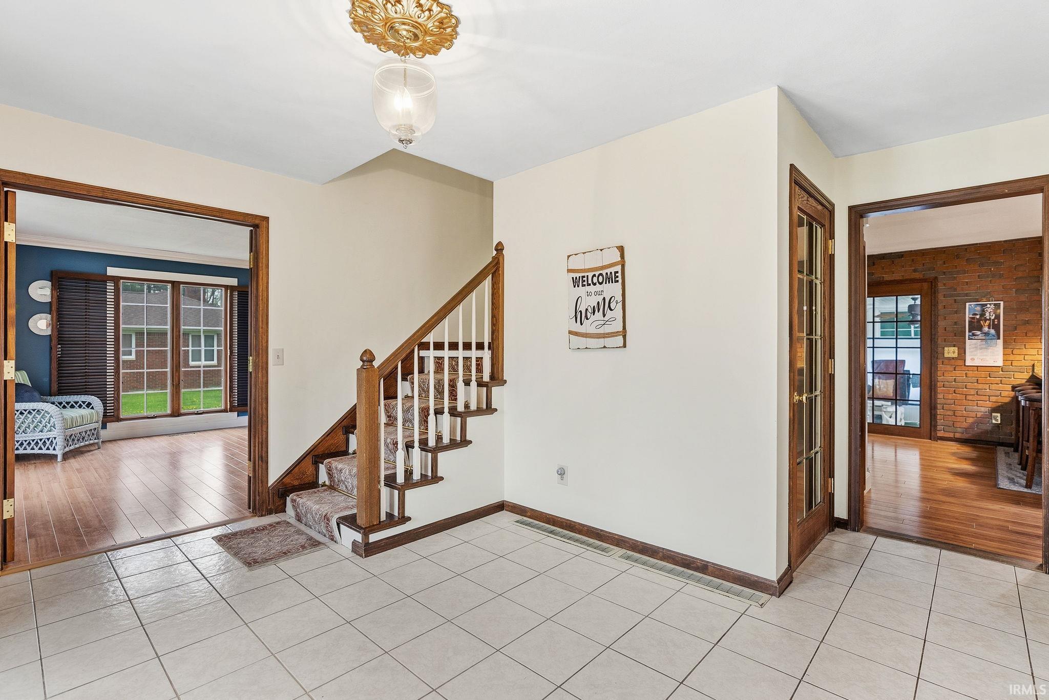 Image 3: Entryway featuring light tile patterned floors, brick wall, and plenty of natural light, Entrance Foyer Image 3: Entryway featuring light tile patterned floors, brick wall, and plenty of natural light, Entrance Foyer