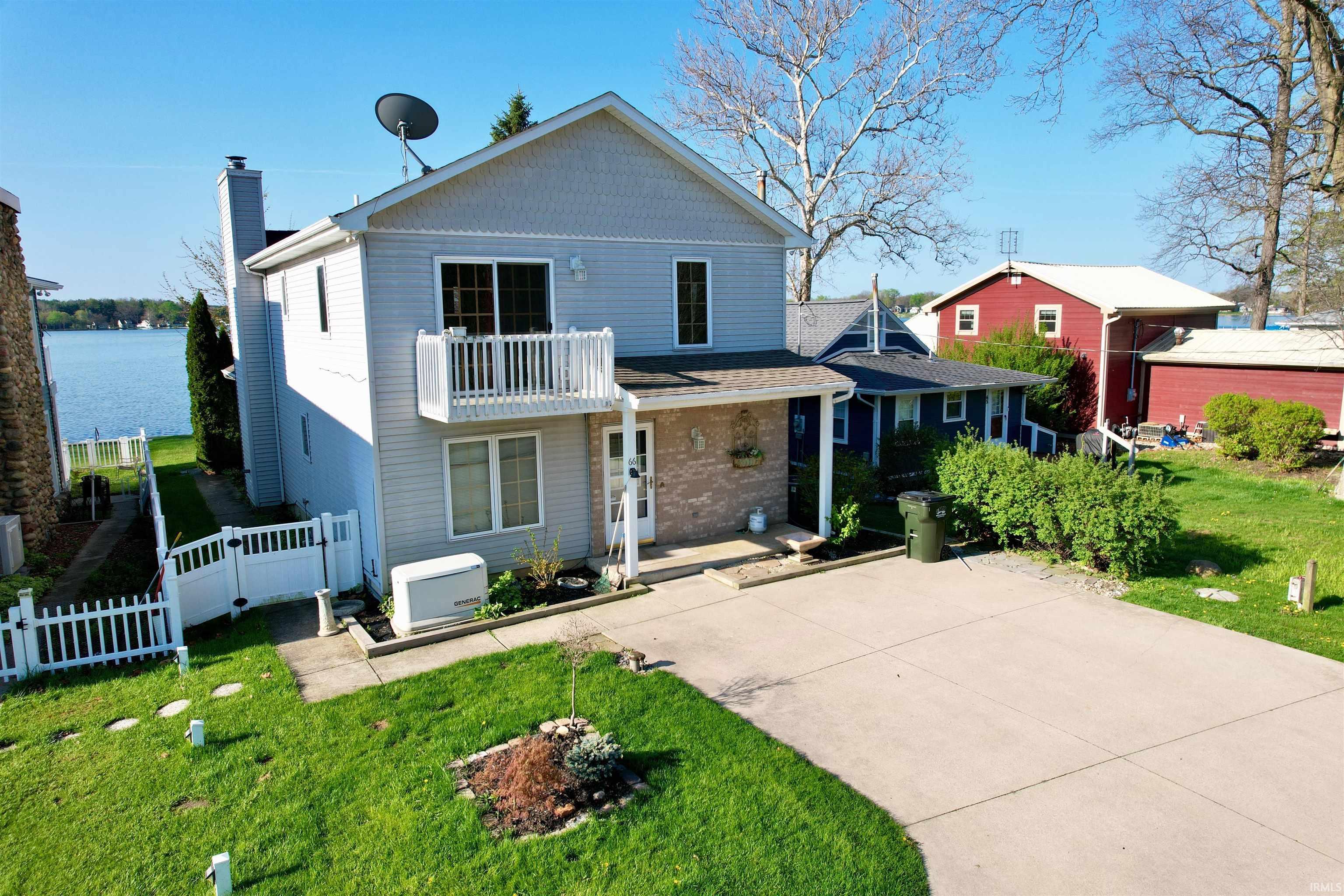 Image 2: Two-story residence featuring light-colored siding and a balcony, Front Of Structure