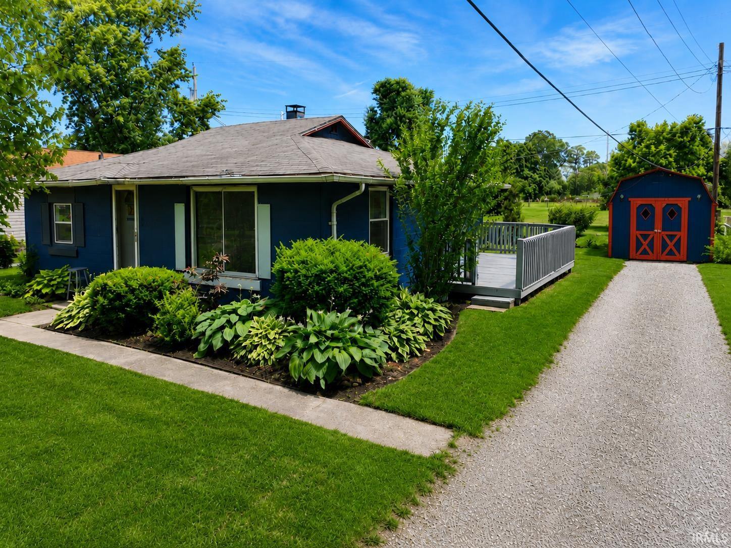 Image 1: Blue exterior residence featuring a gray shingle roof and white window shutters, Front Of Structure Image 1: Blue exterior residence featuring a gray shingle roof and white window shutters, Front Of Structure