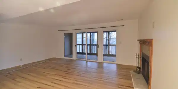 Image 3: Unfurnished living room with a fireplace, light wood-style floors, and a textured ceiling Image 3: Unfurnished living room with a fireplace, light wood-style floors, and a textured ceiling