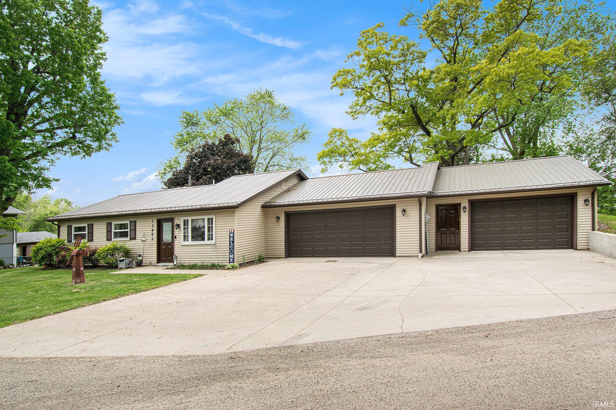 Image 0: Ranch-style house featuring a metal roof, an attached garage, and concrete driveway, Front Of Structure