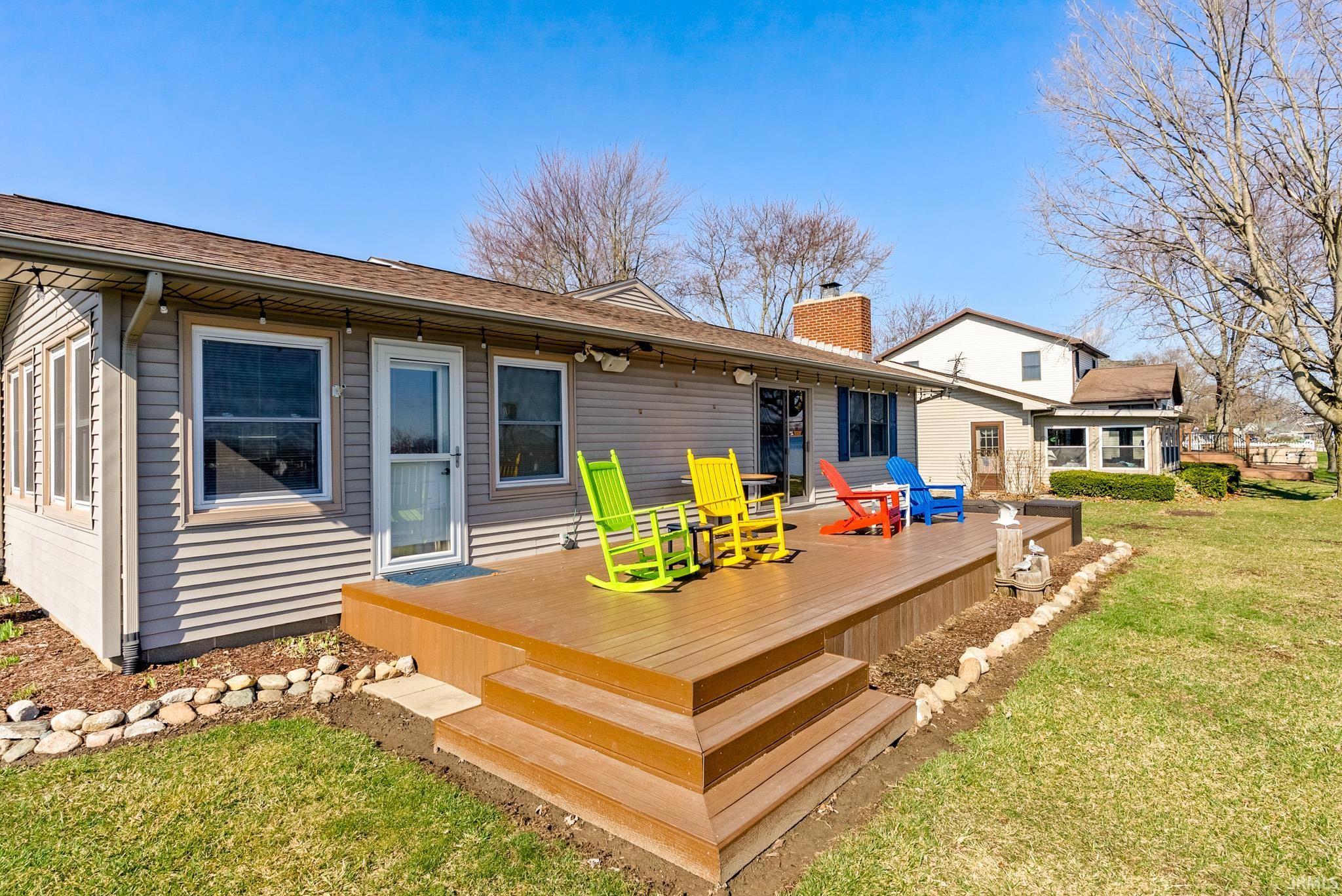 Image 0: Back of property with a lawn, a wooden deck, a chimney, and a shingled roof, Back Of Structure