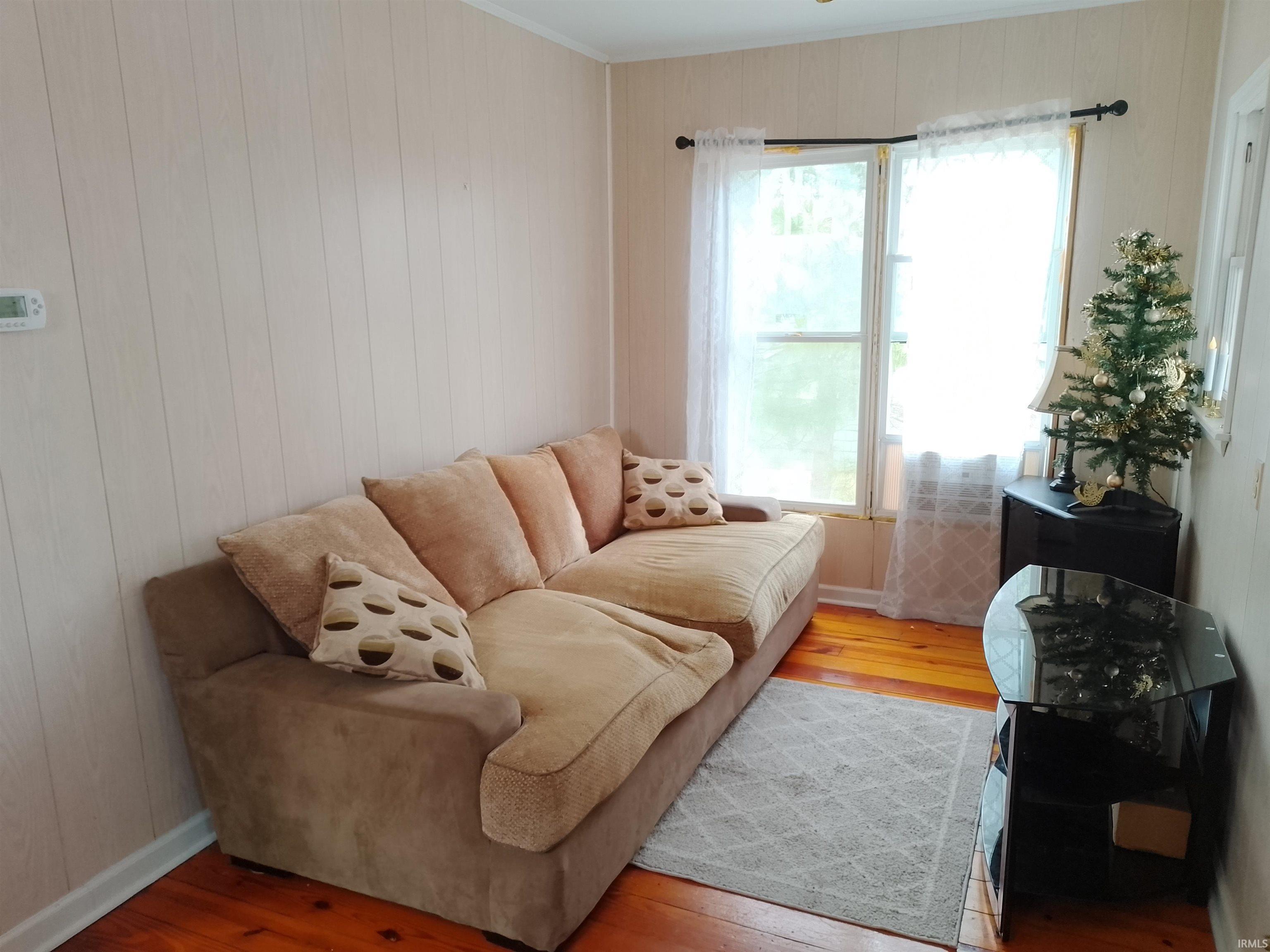 Image 3: Living area with hardwood / wood-style flooring and wood walls, Living Room