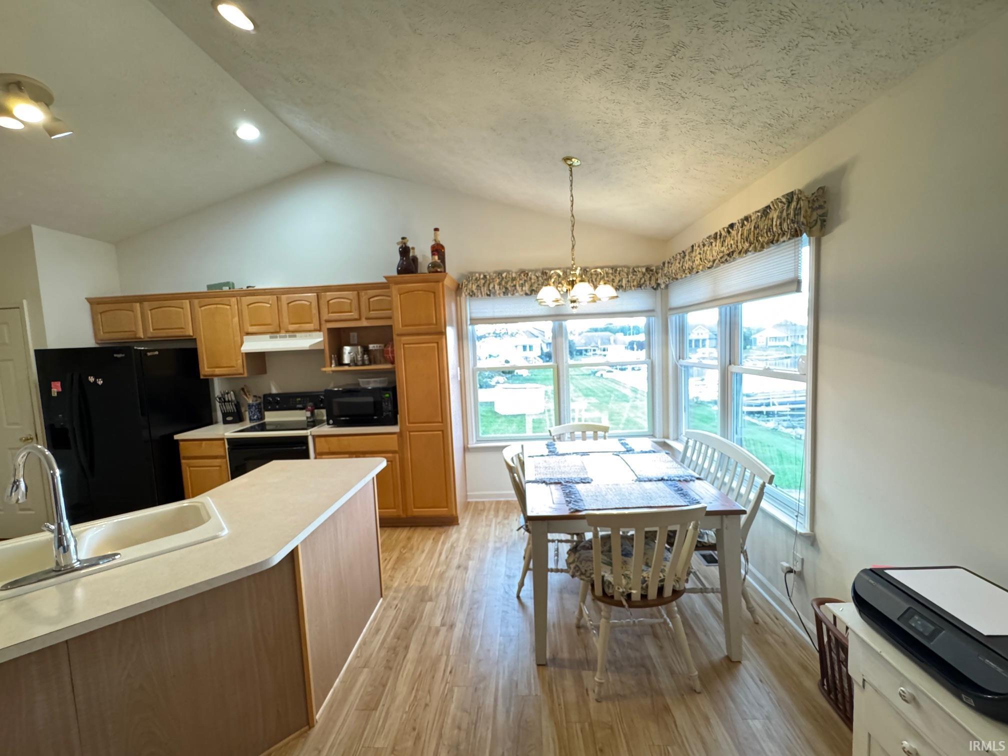 Image 2: Kitchen and dining area featuring a vaulted ceiling with recessed lighting, Kitchen