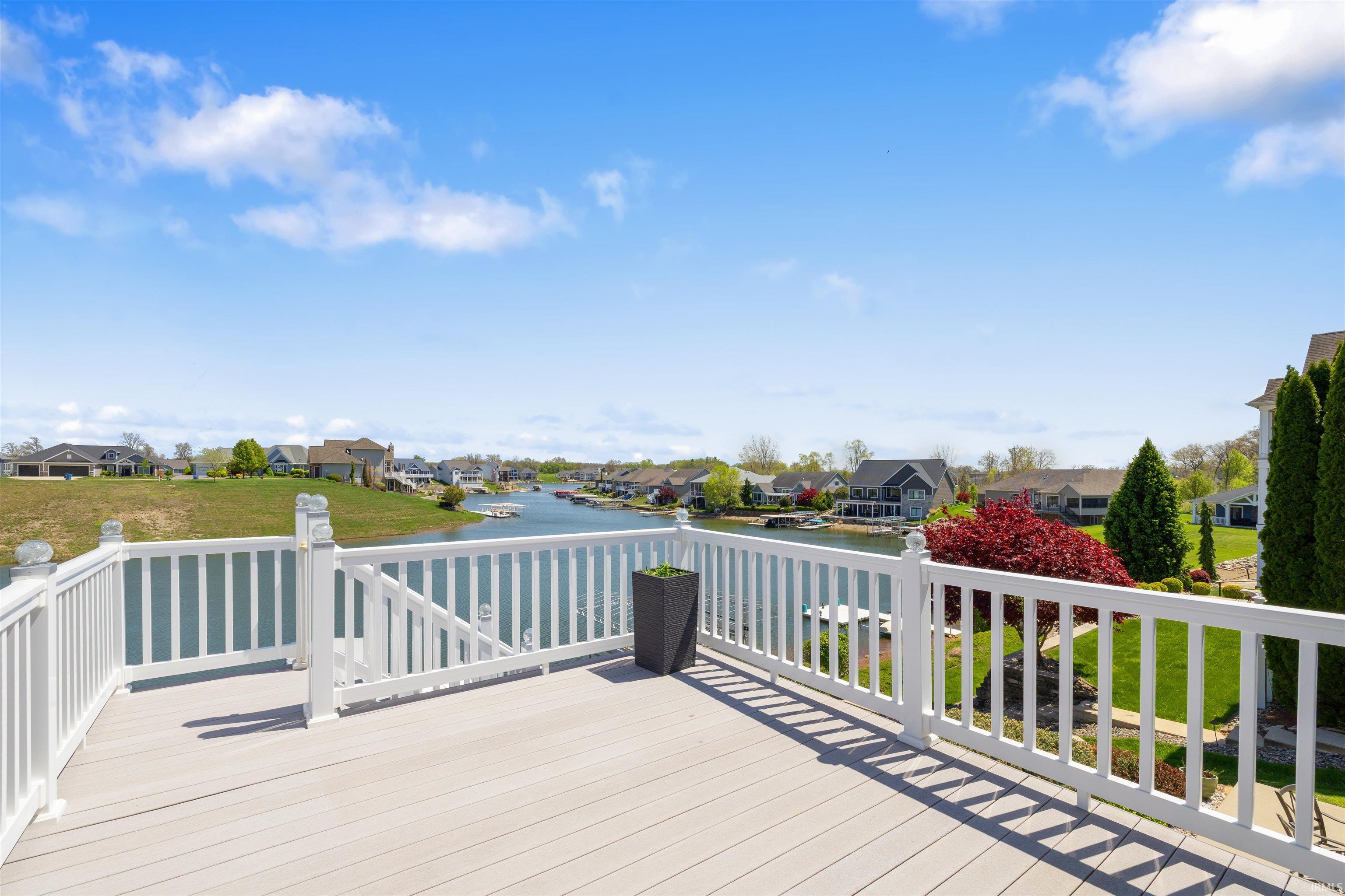 Image 3: Expansive elevated deck with composite decking and white railing, overlooking a waterfront landscape, Deck Image 3: Expansive elevated deck with composite decking and white railing, overlooking a waterfront landscape, Deck