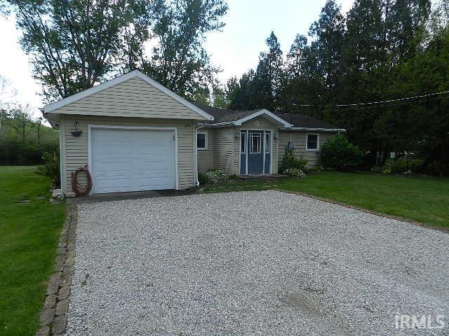 Image 1: Front exterior featuring a gravel driveway, attached garage, and light-colored siding, Front Of Structure Image 1: Front exterior featuring a gravel driveway, attached garage, and light-colored siding, Front Of Structure