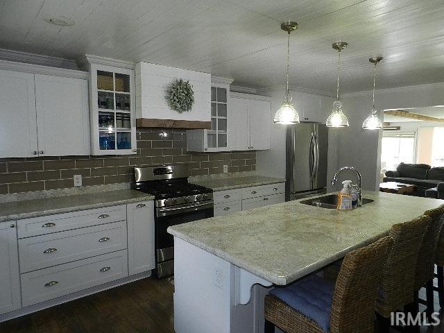 Image 3: Kitchen featuring white cabinetry, subway tile backsplash, stainless steel appliances, and a central island with an undermount sink, Kitchen Image 3: Kitchen featuring white cabinetry, subway tile backsplash, stainless steel appliances, and a central island with an undermount sink, Kitchen