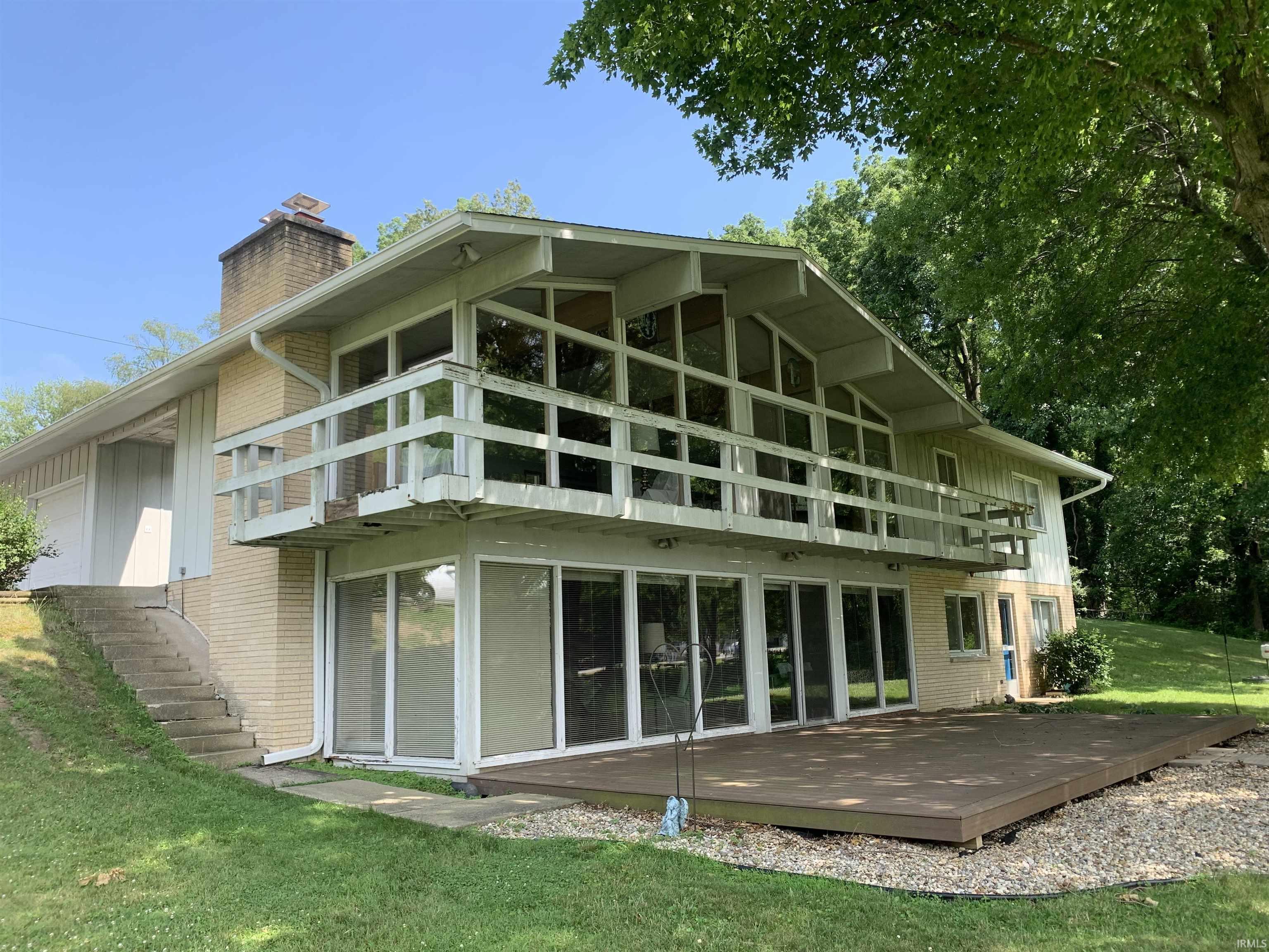 Image 0: Rear view of property with a balcony, brick siding, a yard, and a chimney, Back Of Structure