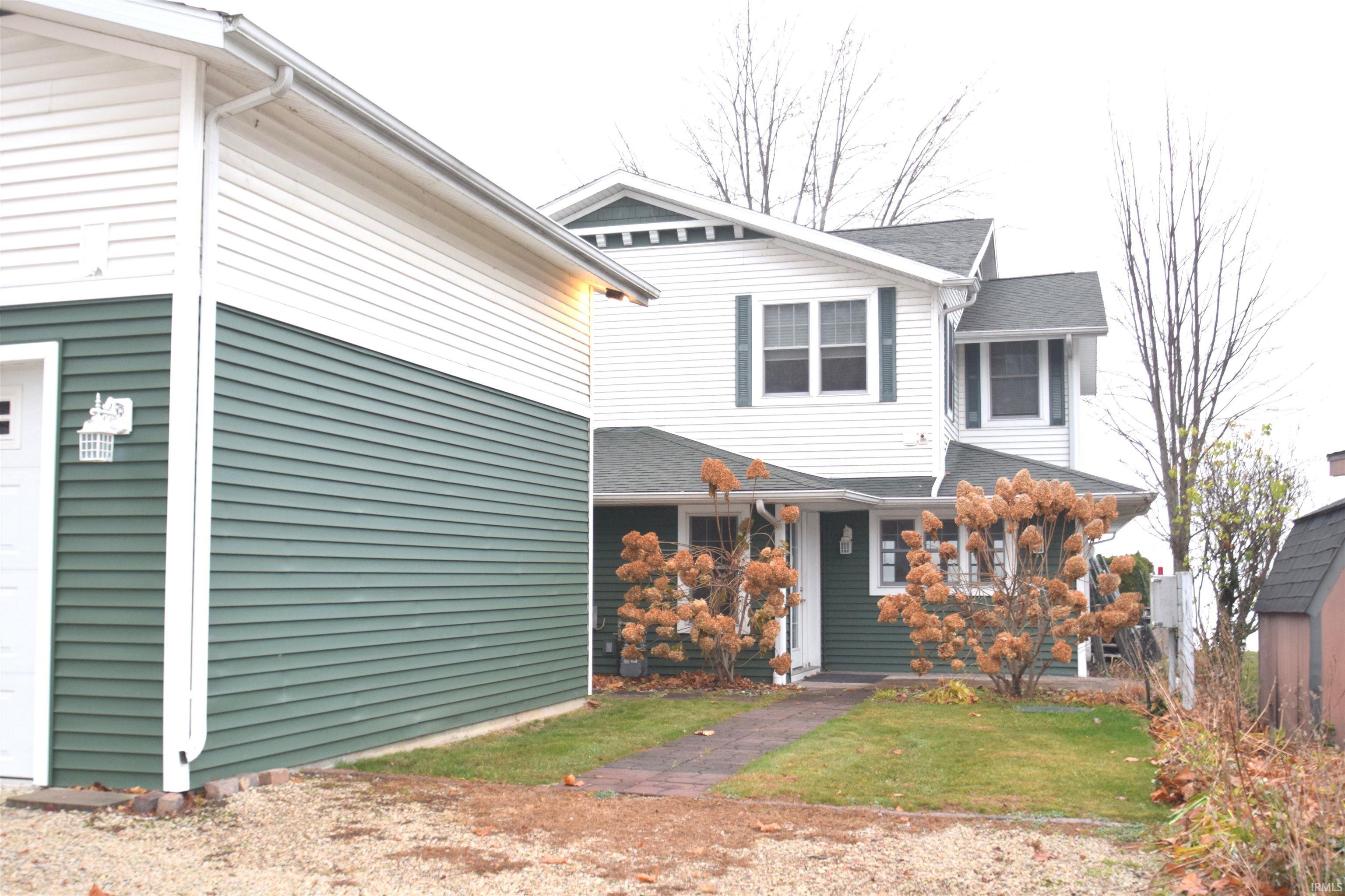 Image 2: View of front of home with a garage and a front lawn, Roadside view of home