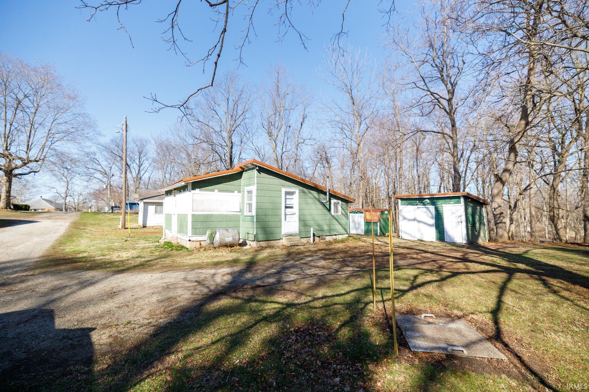 Image 3: View of side of property featuring an outbuilding, a yard, and crawl space, Side Of Structure