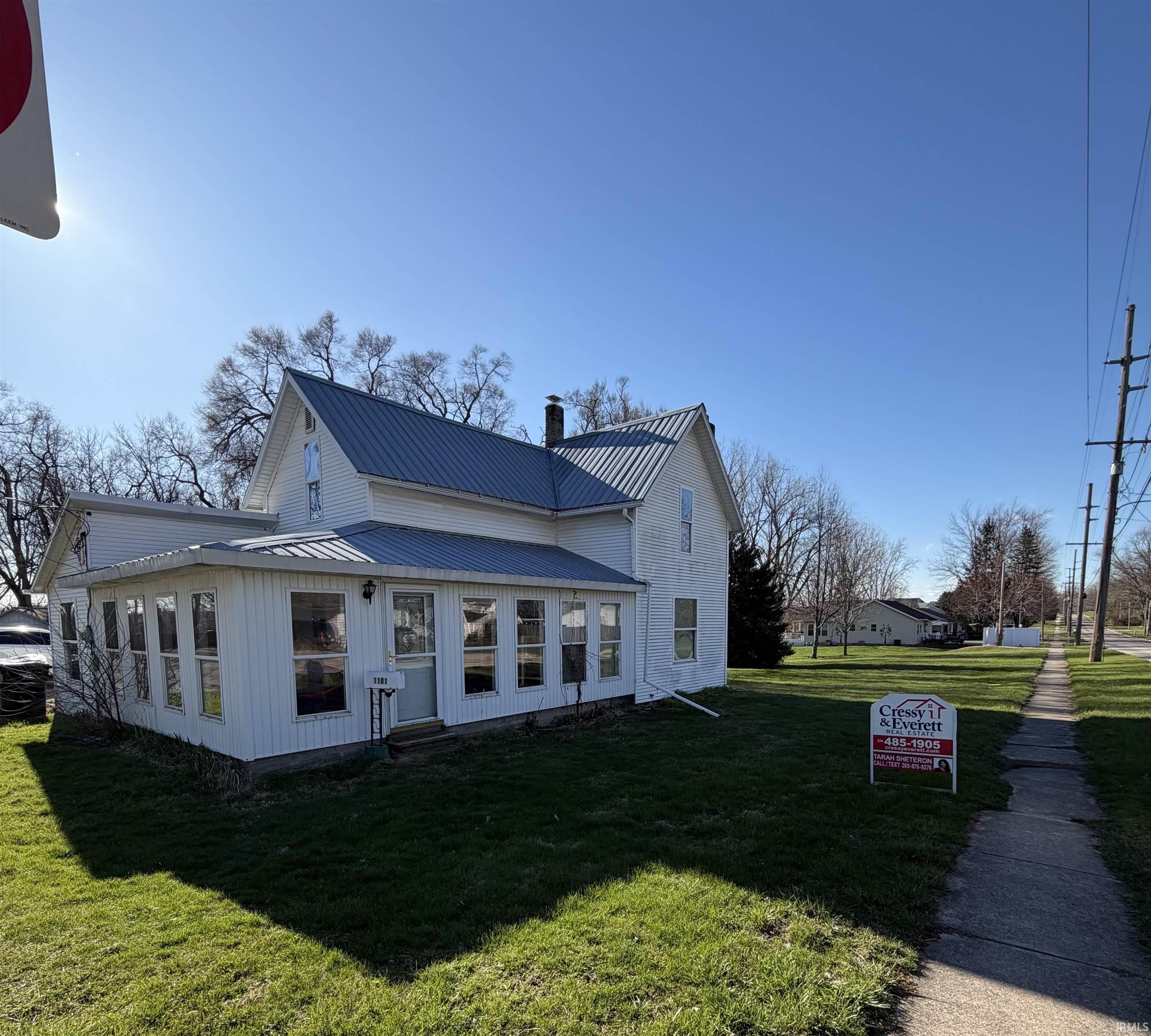 Image 2: View of front of house featuring a front lawn, a metal roof, a chimney, and board and batten siding, Front Of Structure