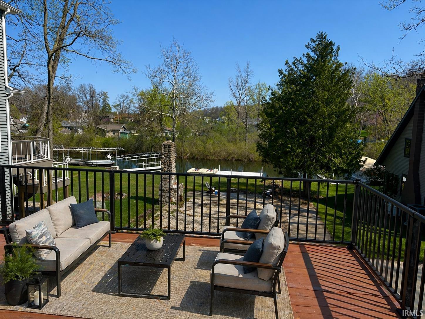 Image 3: Expansive outdoor deck featuring wood-finish flooring and black metal railings, Patio